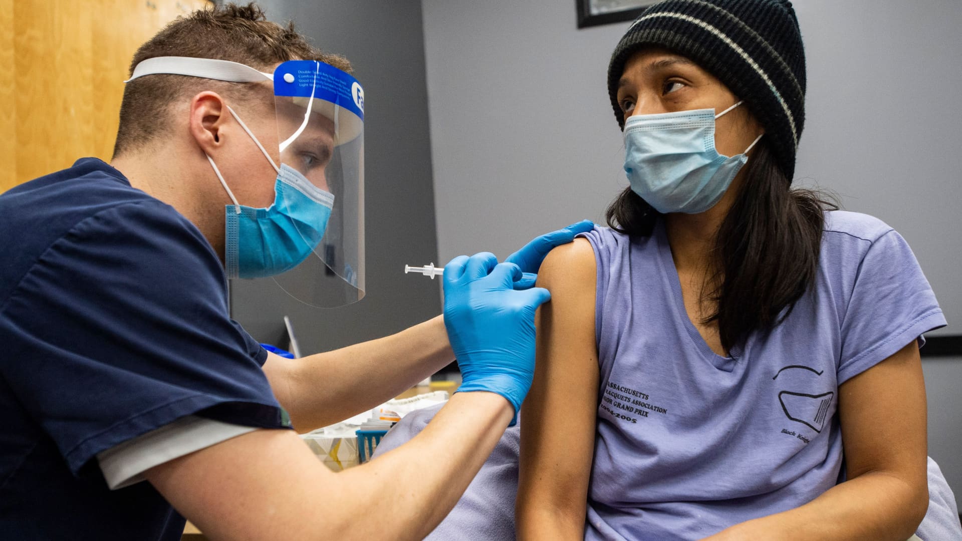 Edith Arangoitia, 46, (who came as a companion to her elderly mother) is vaccinated with the Pfizer-BioNTech Covid-19 vaccine by Doctor Galen Harnden at La Colaborativa in Chelsea, Massachusetts on February 16, 2021.