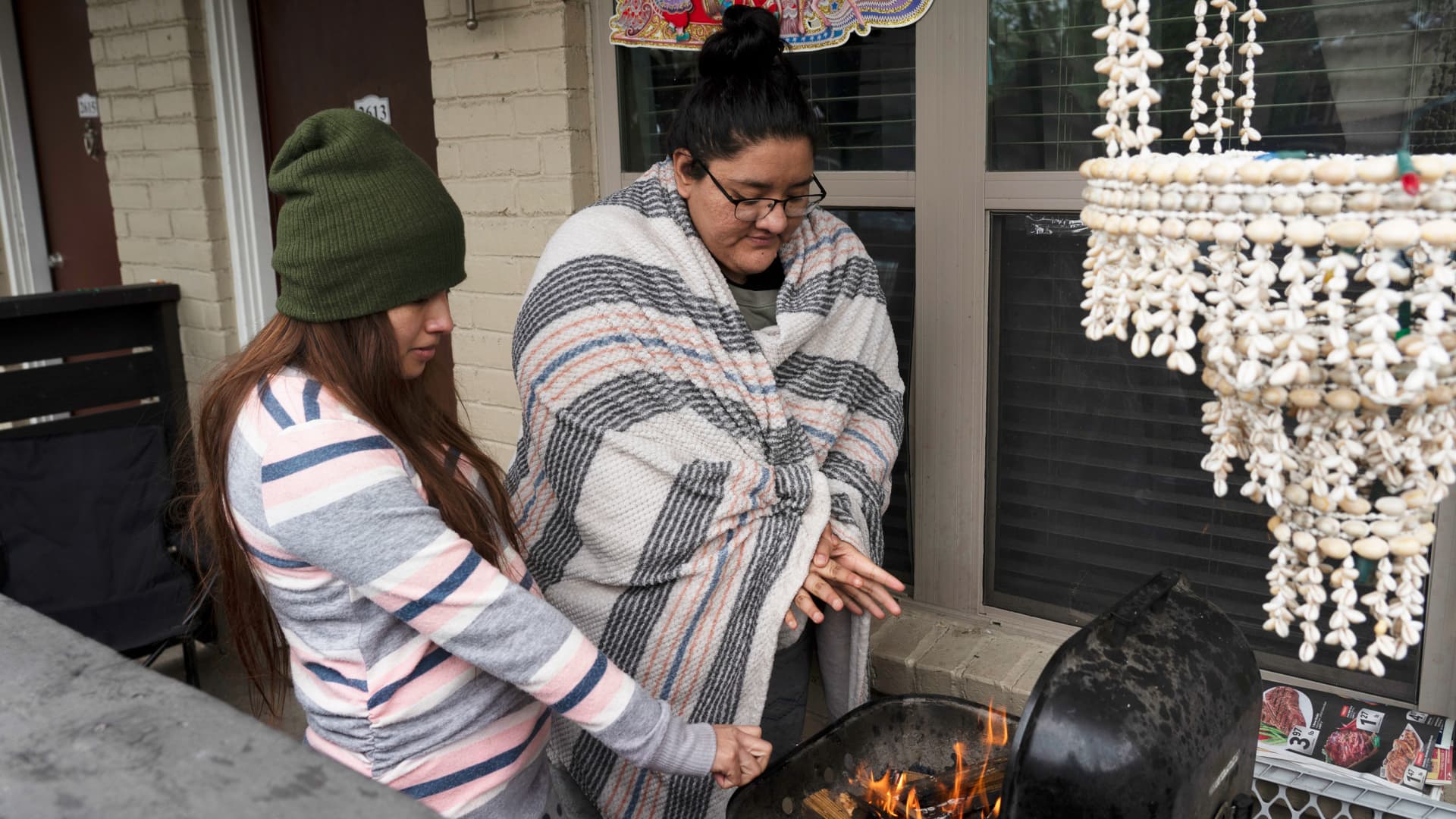Karla Perez and Esperanza Gonzalez warm up by a barbecue grill during power outage caused by the winter storm on February 16, 2021 in Houston, Texas. Winter storm Uri has brought historic cold weather, power outages and traffic accidents to Texas as storms have swept across 26 states with a mix of freezing temperatures and precipitation.