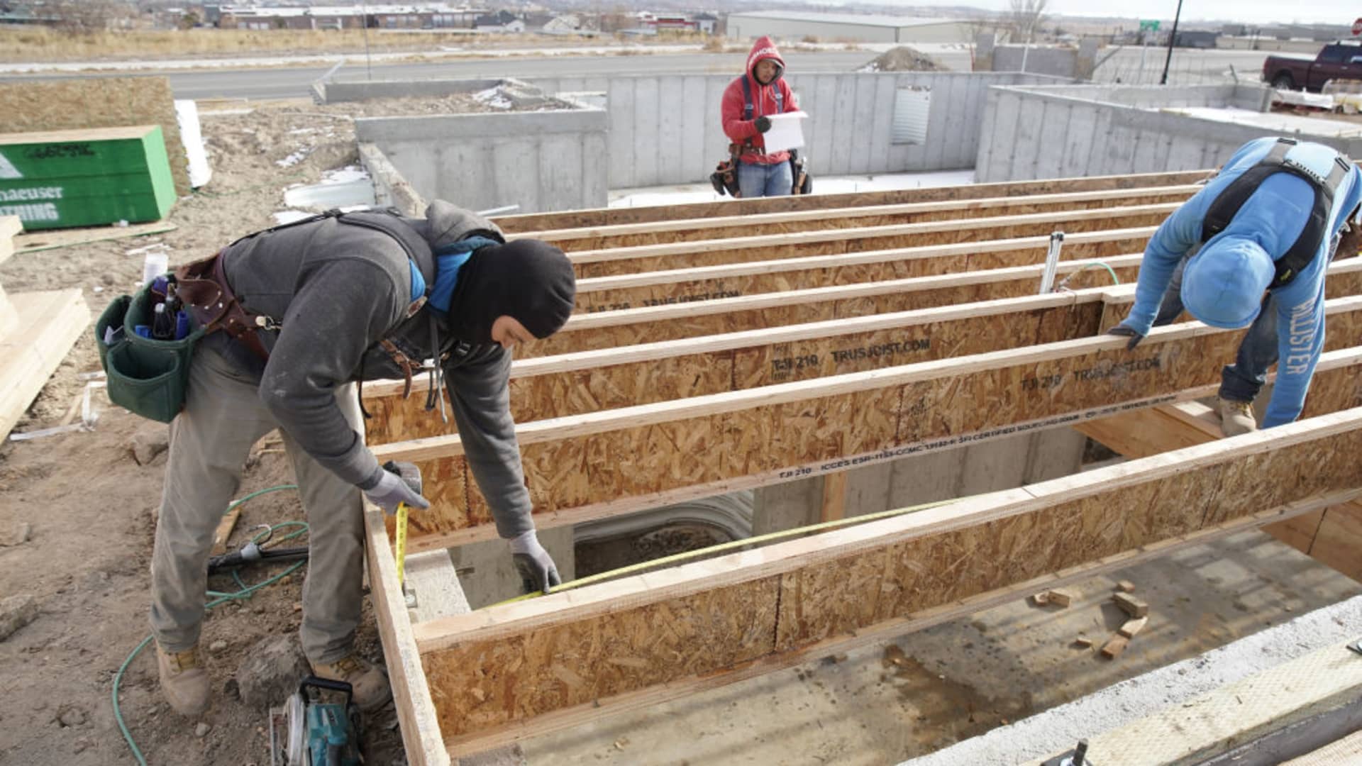 Contractors install floor beams on the foundation of a house under construction in Lehi, Utah, Dec. 16, 2020.