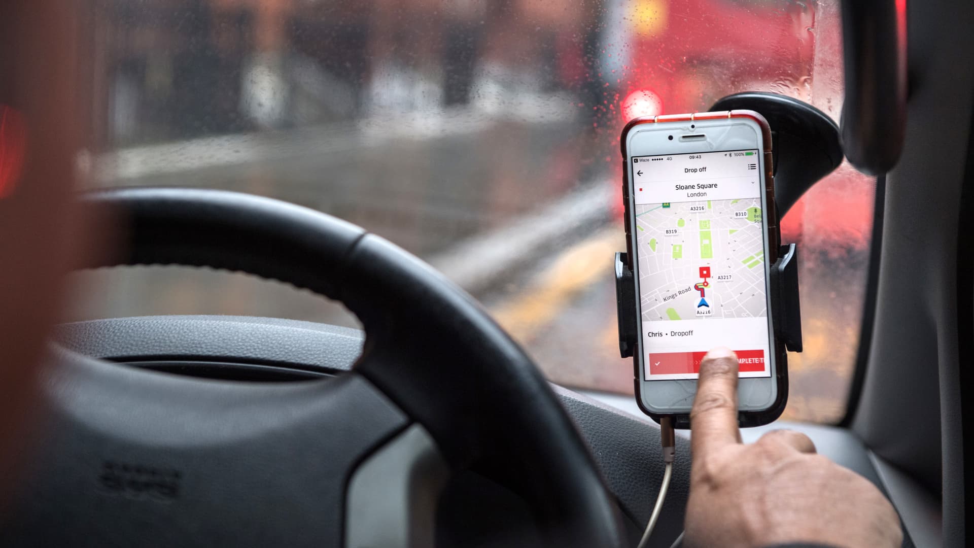 A driver uses the Uber app to drop off a passenger in London.