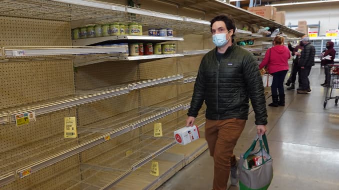 Kupujący przechodzi obok gołej półki, gdy ludzie zaopatrują się w artykuły pierwszej potrzeby w sklepie spożywczym HEB 18 lutego 2021 roku w Austin w Teksasie.