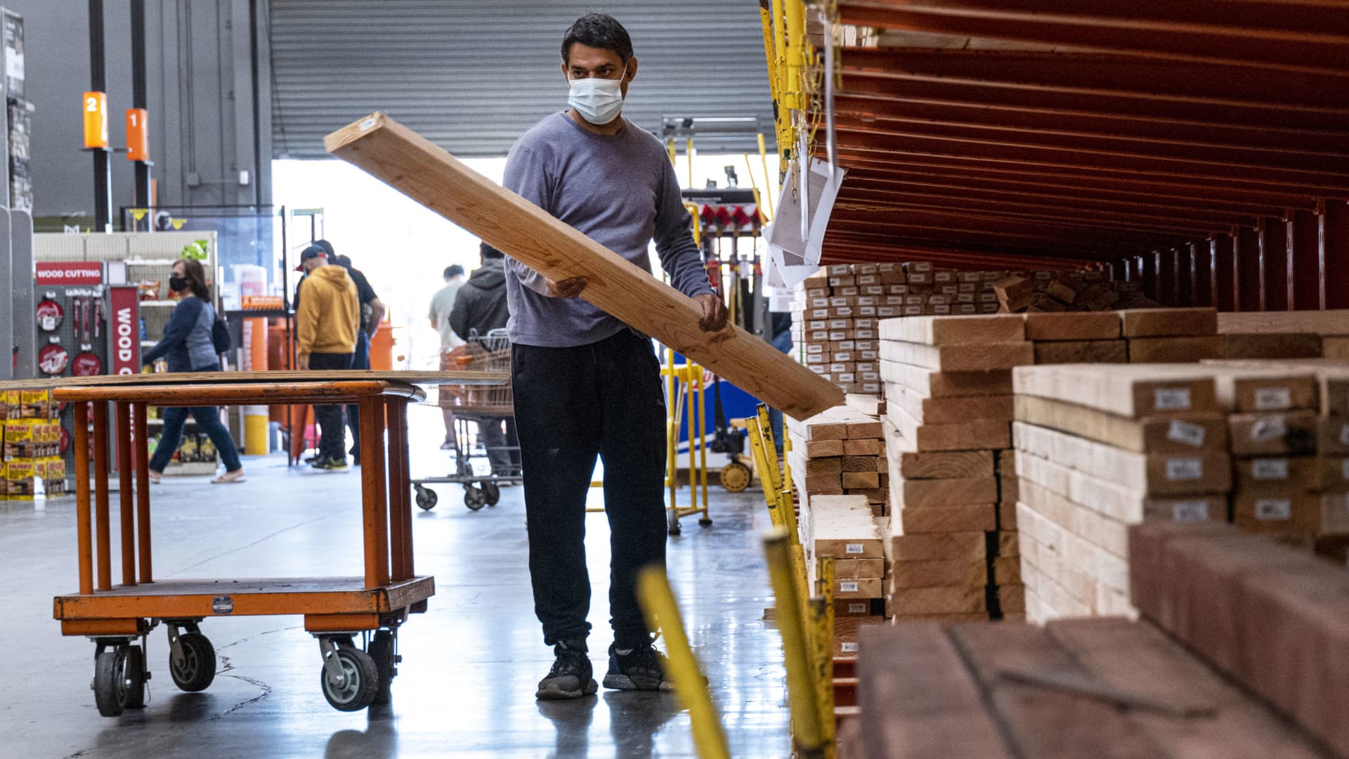 A customer wearing a protective mask loads lumber at a Home Depot store in Pleasanton, California, Feb. 22, 2021.
