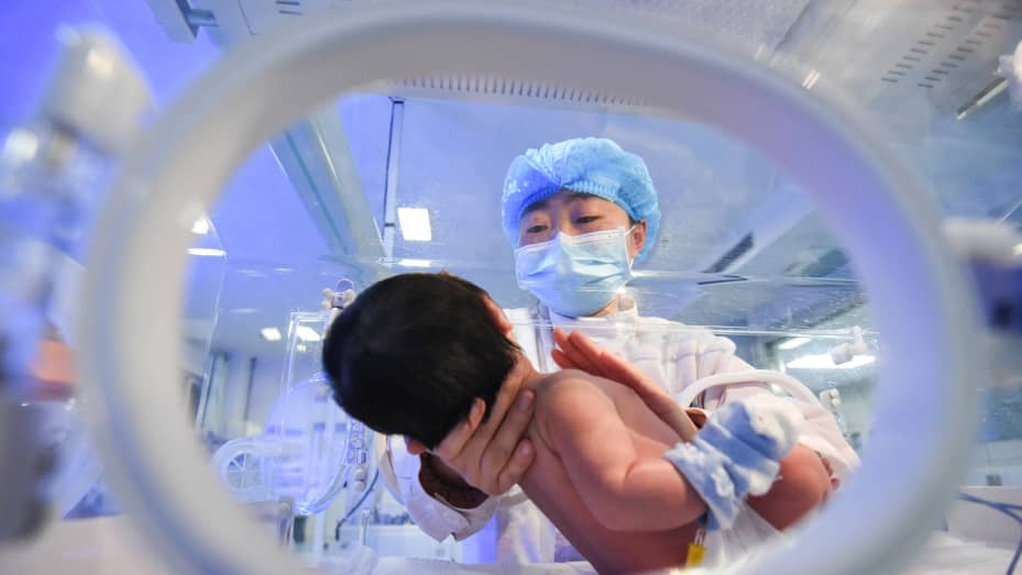 A medical worker takes care of a newborn baby lying inside an incubator at Jingzhou Maternity & Child Healthcare Hospital on the eve of Chinese New Year, the Year of the Ox, on Feb. 11, 2021 in Jingzhou, Hubei Province of China.