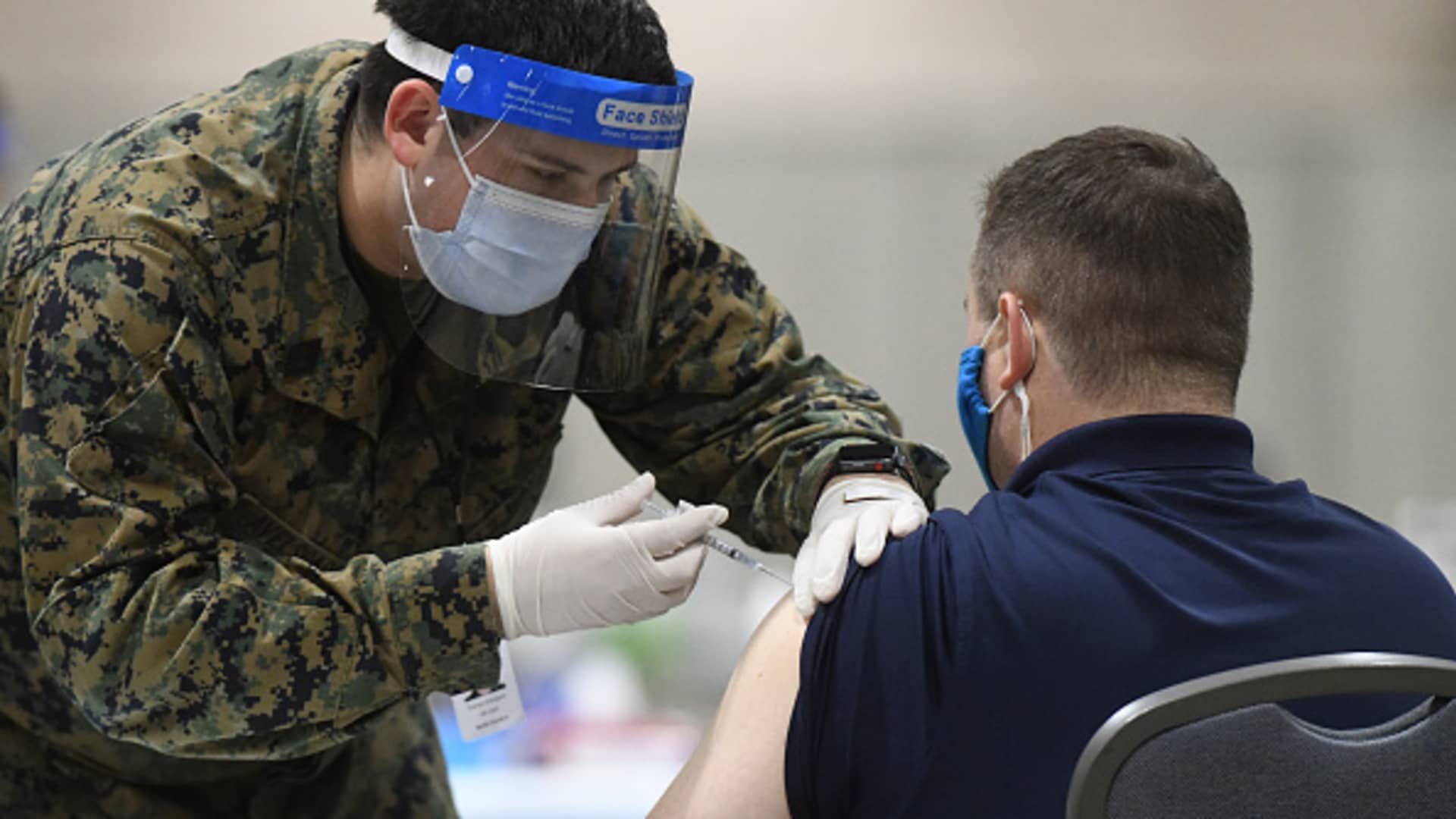 A member of the U.S. Armed Forces administers a COVID-19 vaccine to a police officer at a FEMA community vaccination center on March 2, 2021 in Philadelphia, Pennsylvania.