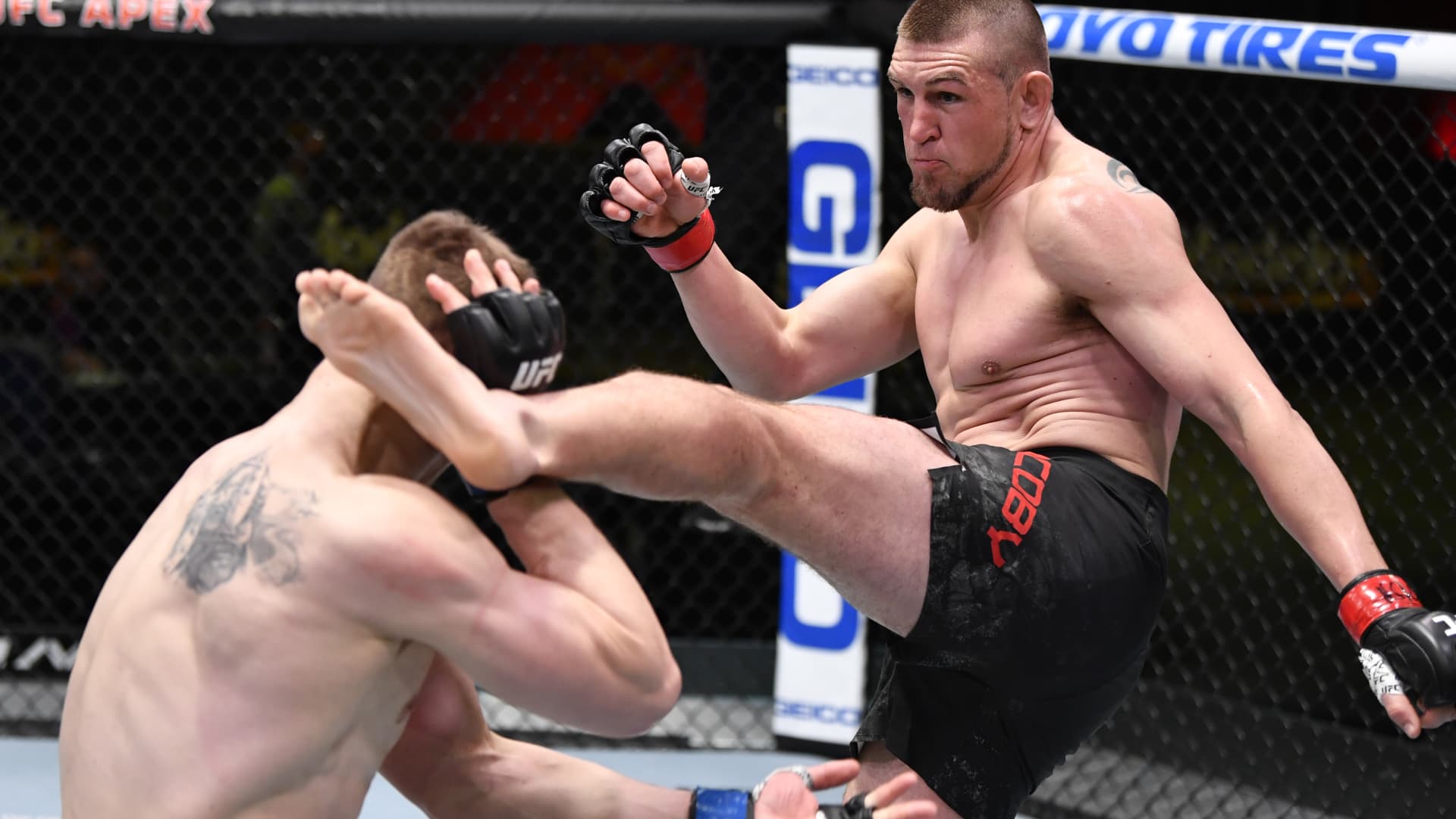 In this handout image provided by UFC, (R-L) Dustin Jacoby kicks Maxim Grishin of Russia in a light heavyweight bout during the UFC Fight Night event at UFC APEX on February 27, 2021 in Las Vegas, Nevada.