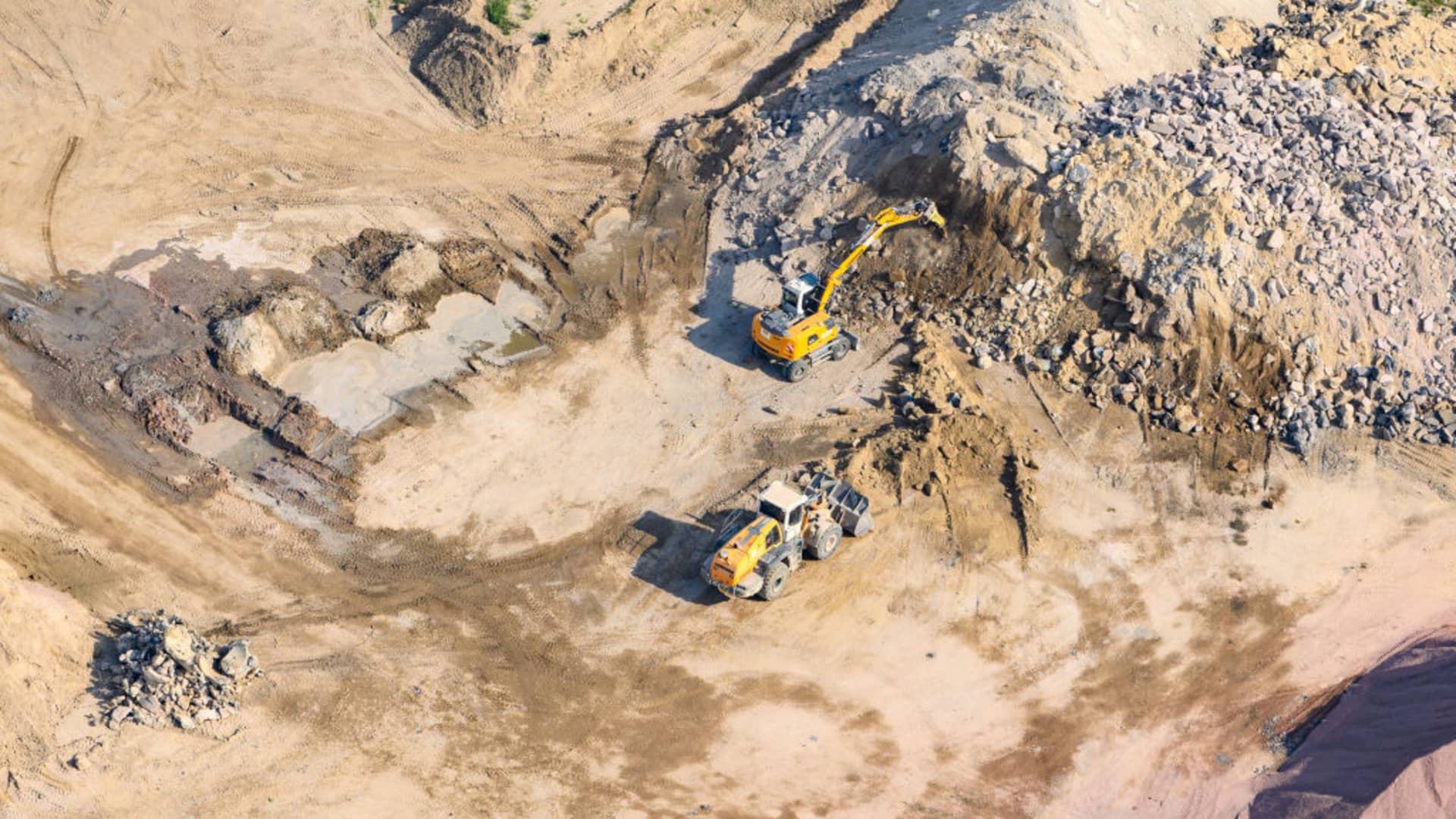An excavator and a bulldozer are working on the grounds of the gravel plant and the concrete mixing plant of the Max Bögl group of companies.