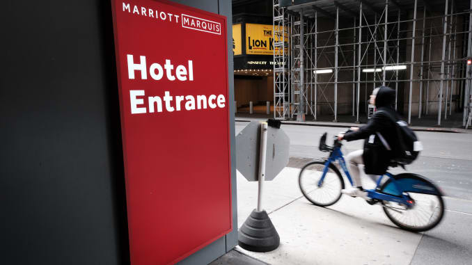 A person rides a bike past the Marriott hotel in Times Square, New York.