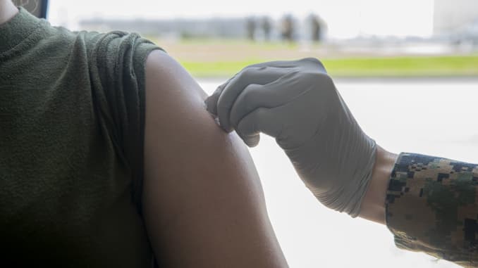 U.S. Marine Corps Staff Sgt. Felicia White, a supply chief with Camp Kinser Post Office, gets her arm disinfected to receive her second dose of the COVID-19 vaccine at the U.S. Naval Hospital Okinawa, on Camp Foster, Mar. 2, 2021.