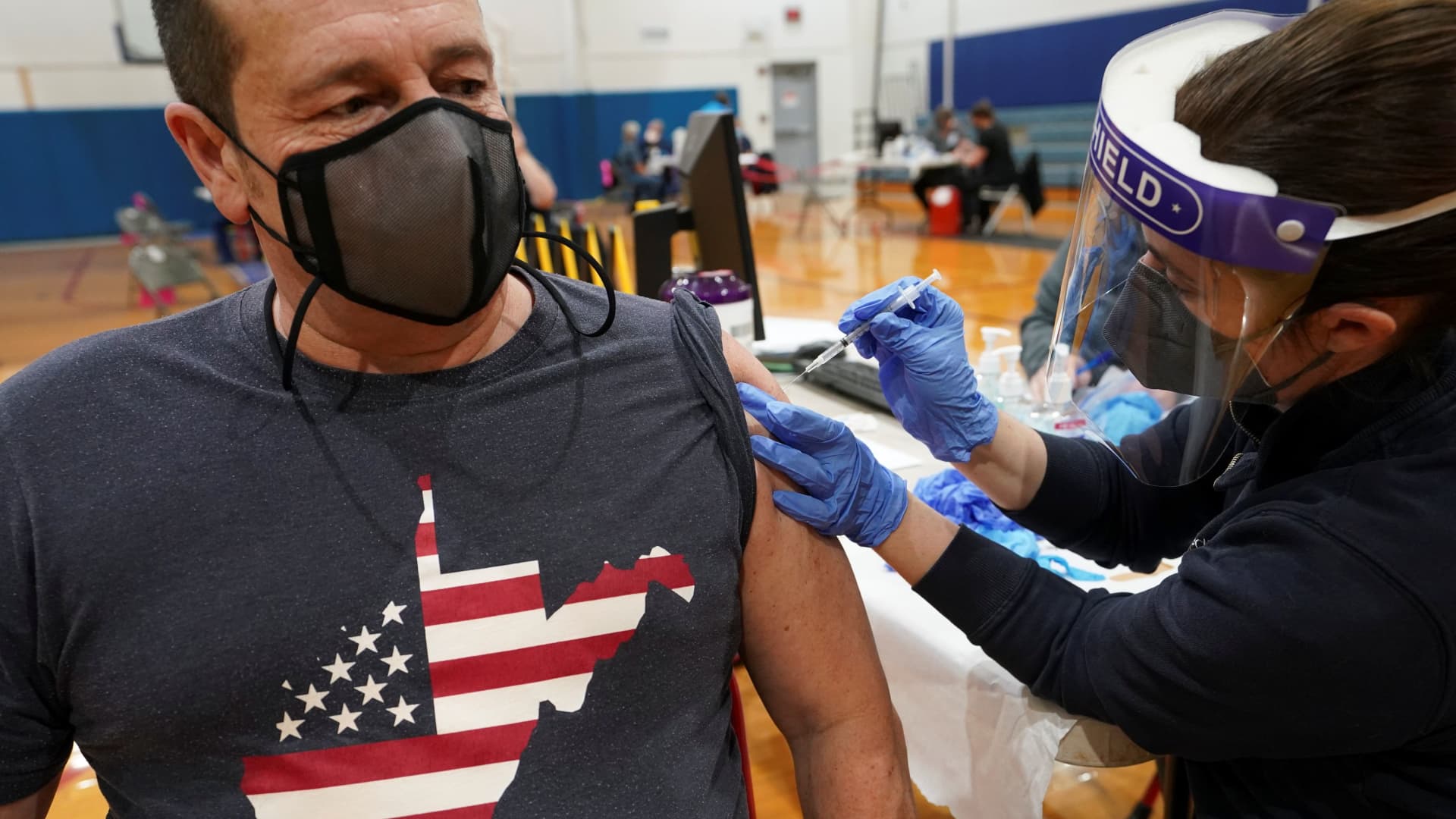Tony Heaton of Falling Waters, wearing a West Virginia t-shirt with stars and stripes, receives a coronavirus disease (COVID-19) vaccine during a community vaccination event in Martinsburg, West Virginia, March 11, 2021.