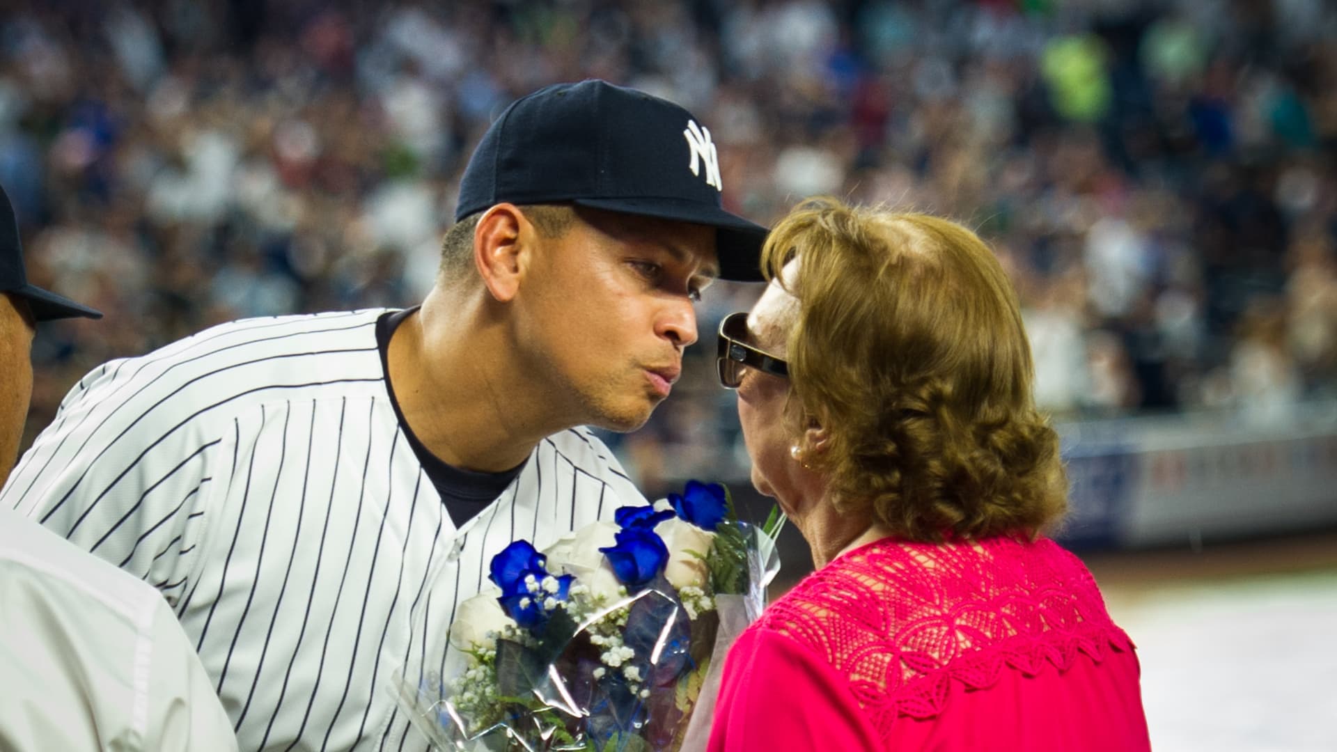 New York Yankees designated hitter Alex Rodriguez (13) is pictured kissing his mother in a pre-game ceremony in the rain before his final game on Friday, August 13, 2016.