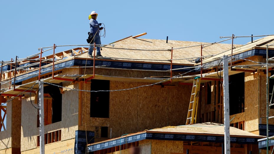 A worker walks on the roof of a new home under construction in Carlsbad, California.