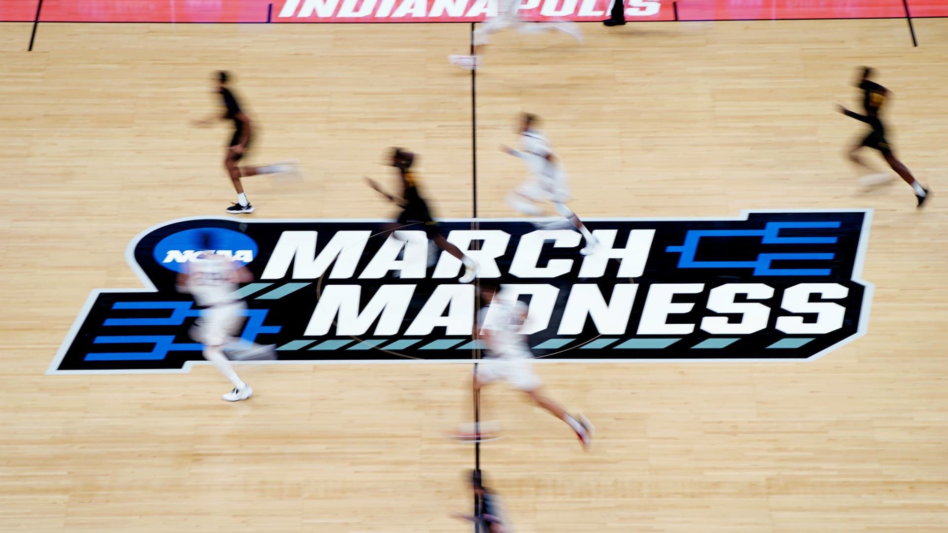 A detailed view of the March Madness logo at center court as Gonzaga Bulldogs and Norfolk State Spartans players run by during the second half in the first round of the 2021 NCAA Tournament at Bankers Life Fieldhouse.