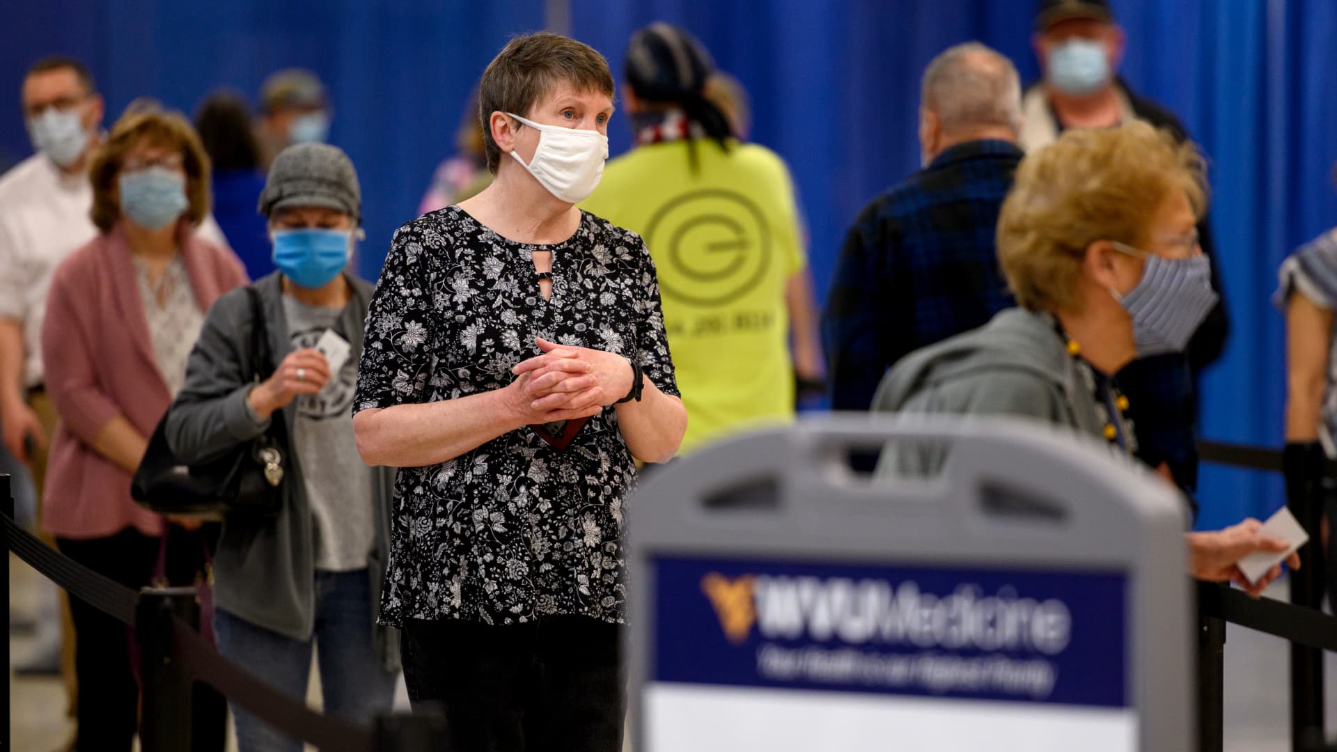 Residents wear protective masks while waiting to be vaccinated at a West Virginia United Health System Covid-19 vaccine clinic in Morgantown, West Virginia, U.S., on Thursday, March 11, 2021.