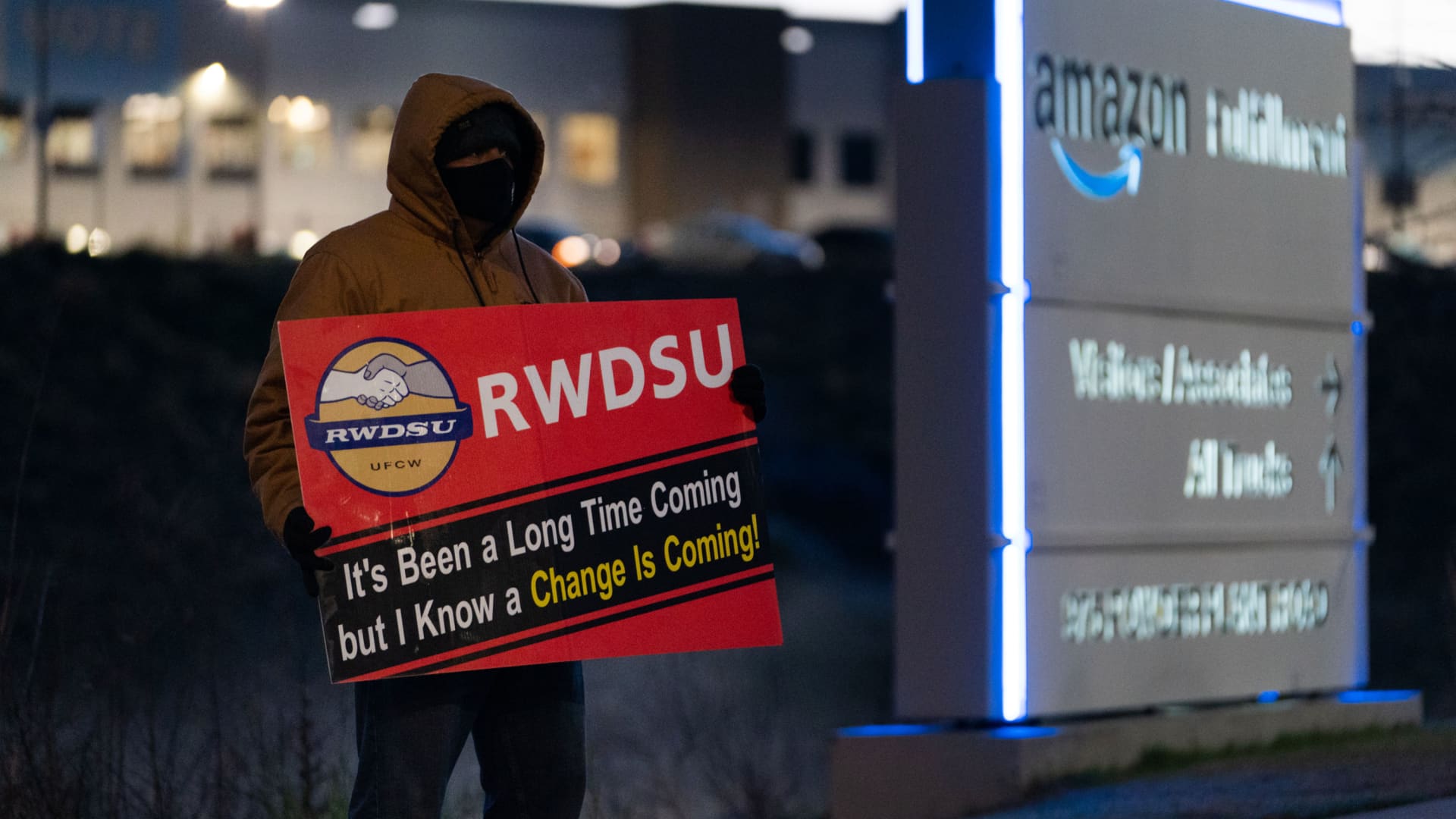 An RWDSU union rep holds a sign outside the Amazon fulfillment warehouse at the center of a unionization drive on March 29, 2021 in Bessemer, Alabama.