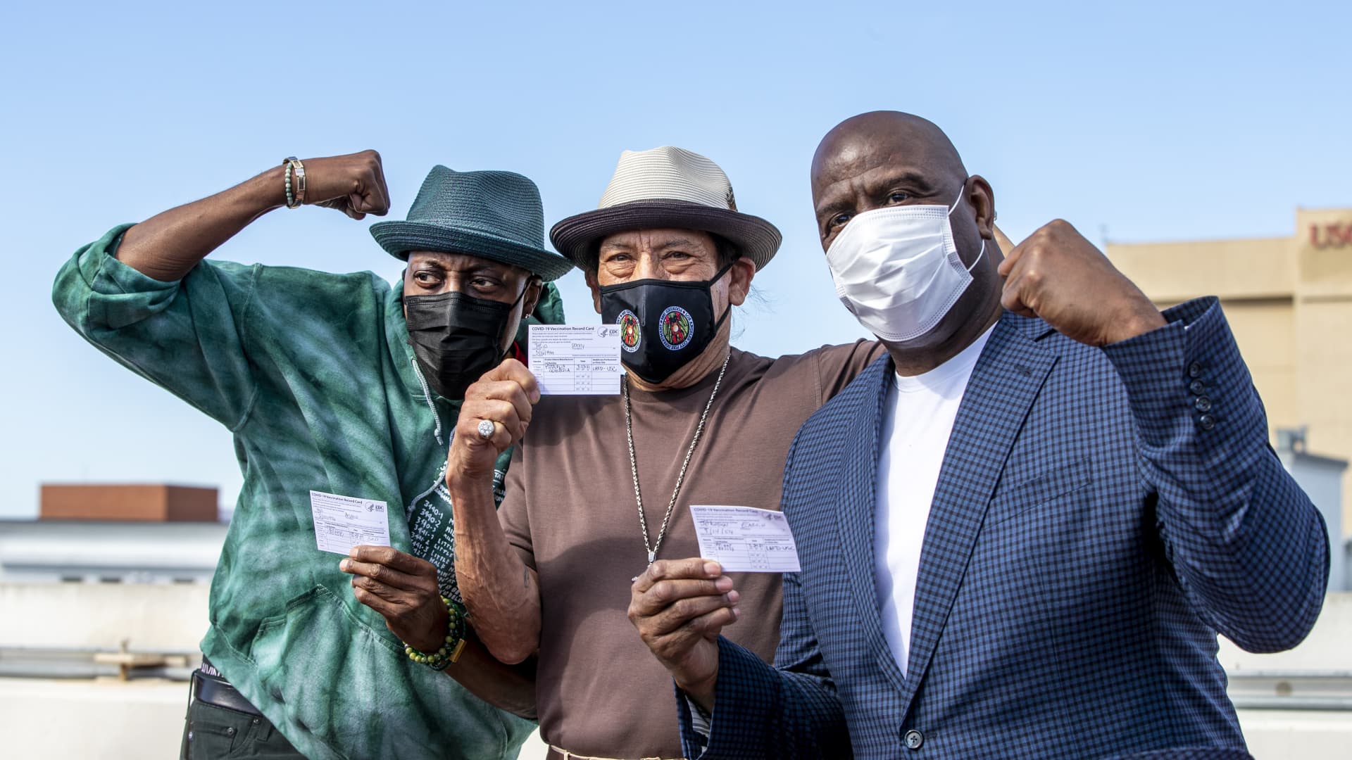 Arsenio Hall, left, Danny Trejo and Magic Johnson pose for a photo after they all got vaccine shots on the rooftop of parking structure at USC as a part of a vaccination awareness event at USC on March 24, 2021 in Los Angeles, California.
