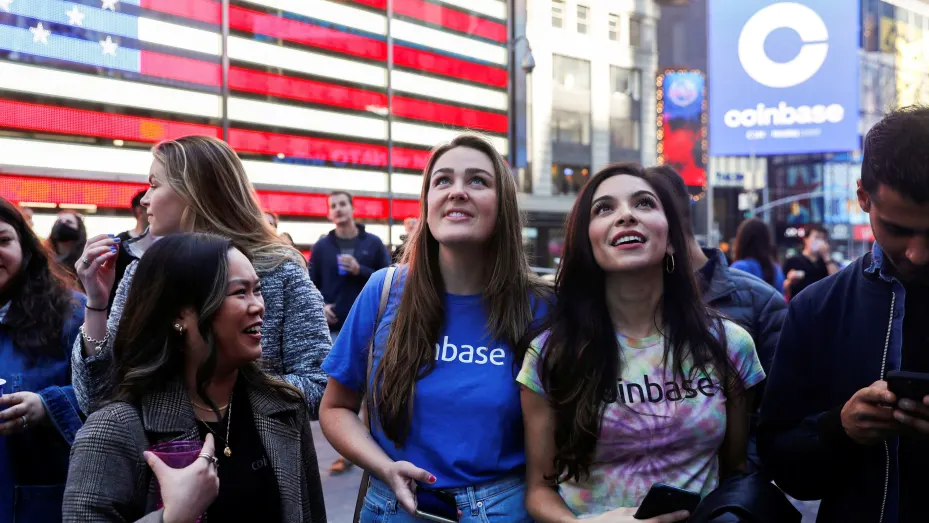 Employees of Coinbase Global Inc, the biggest U.S. cryptocurrency exchange, watch as their listing is displayed on the Nasdaq MarketSite jumbotron at Times Square in New York, U.S., April 14, 2021.