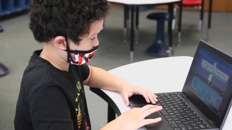 Nine-year-old student Roberto Nieves Fernandez studies personal finance topics on his laptop using online resource center SmartPath.