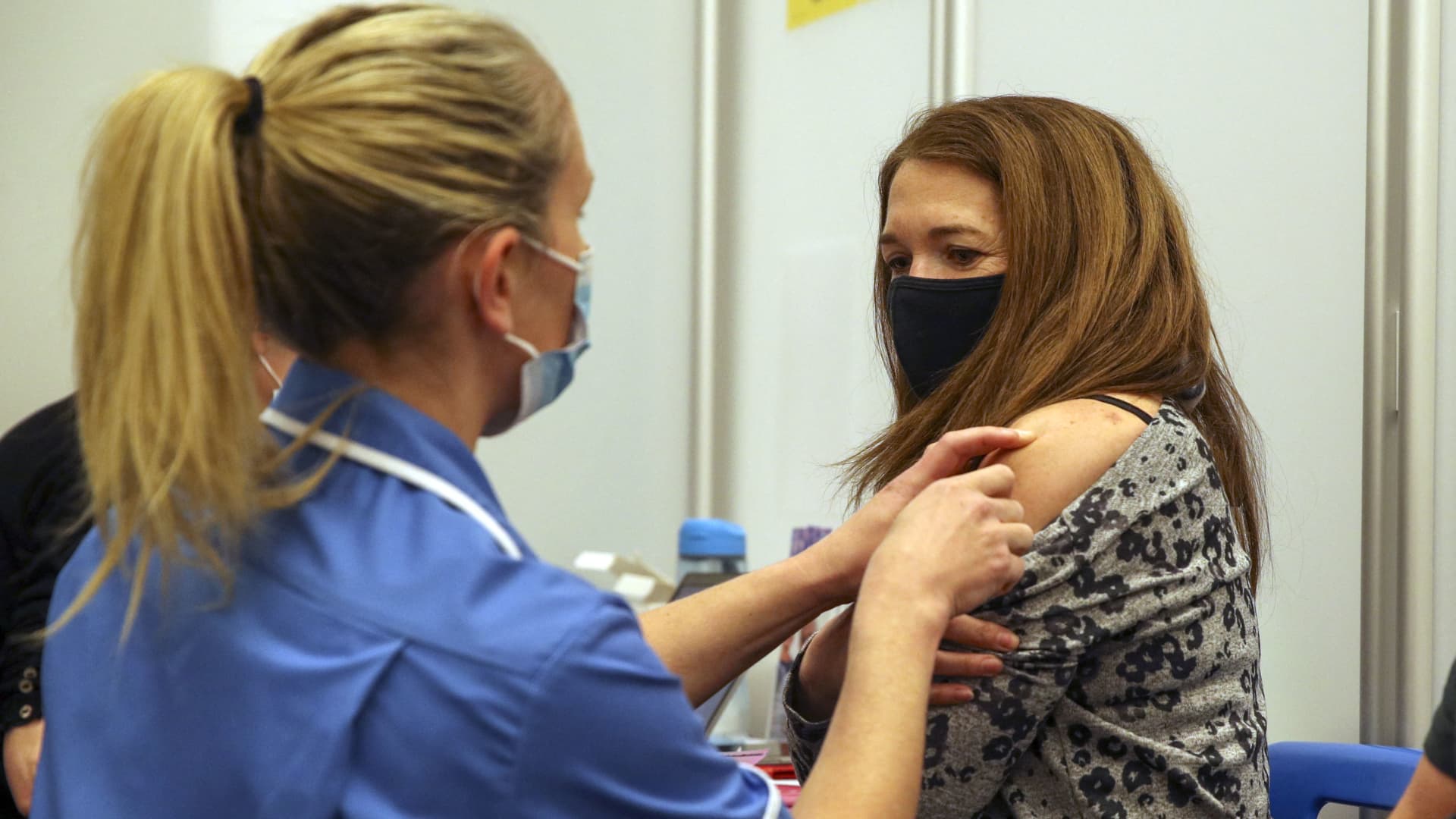 Caroline Nicolls receives an injection of the Moderna Covid-19 vaccine administered by nurse Amy Nash, at the Madejski Stadium in Reading, west of London on April 13, 2021.