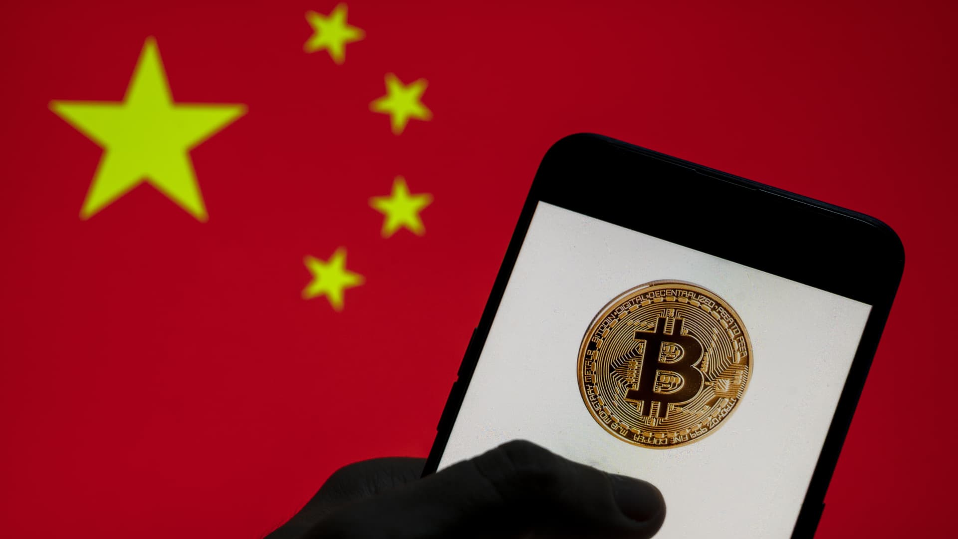 In this photo illustration, the Bitcoin logo is seen on a mobile device with People's Republic of China flag in the background. (Photo Illustration by t/SOPA Images/LightRocket via Getty Images)