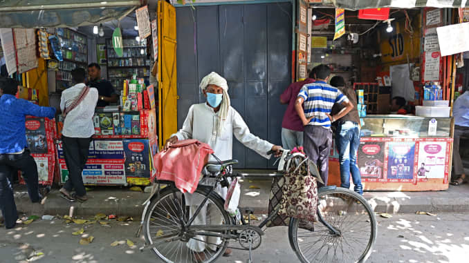 A man with his bicycle on a street in the old quarters of New Delhi on April 19, 2021, as India's capital will impose a week-long lockdown from tonight, officials said, while the megacity struggles to contain a huge surge in Covid-19 cases with hospitals 