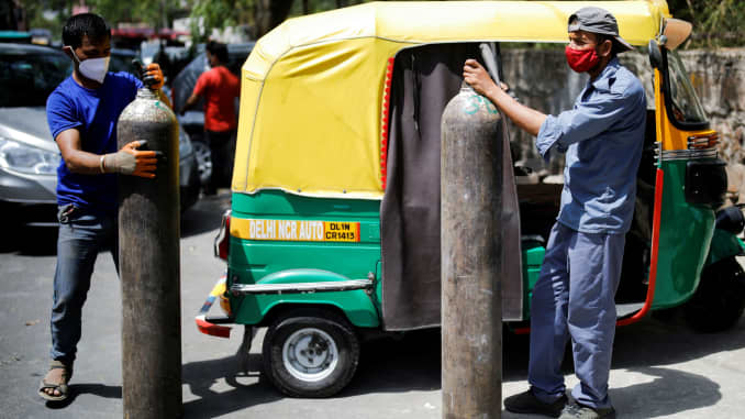 Rickshaw drivers hold oxygen cylinders outside a private refilling station, amid the coronavirus disease (COVID-19) outbreak, in New Delhi, India, April 19, 2021.