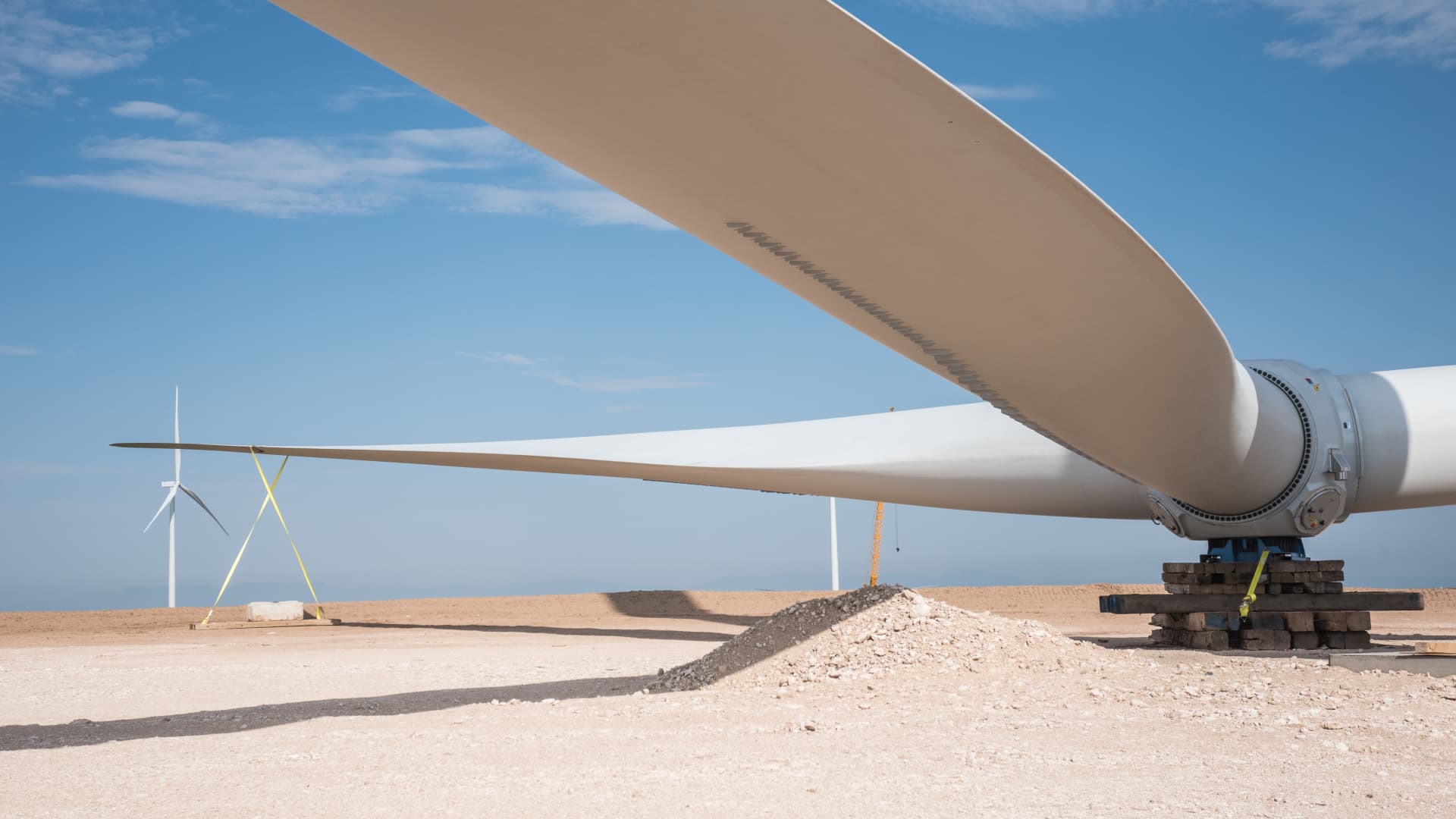 Rotor blades sit on the ground next to a wind turbine under construction at the Avangrid Renewables La Joya wind farm in Encino, New Mexico.