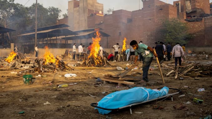 A man prepares a funeral pyre to cremate the body of a person, who died due to the coronavirus disease (COVID-19), at a crematorium ground in New Delhi, India, April 22, 2021.