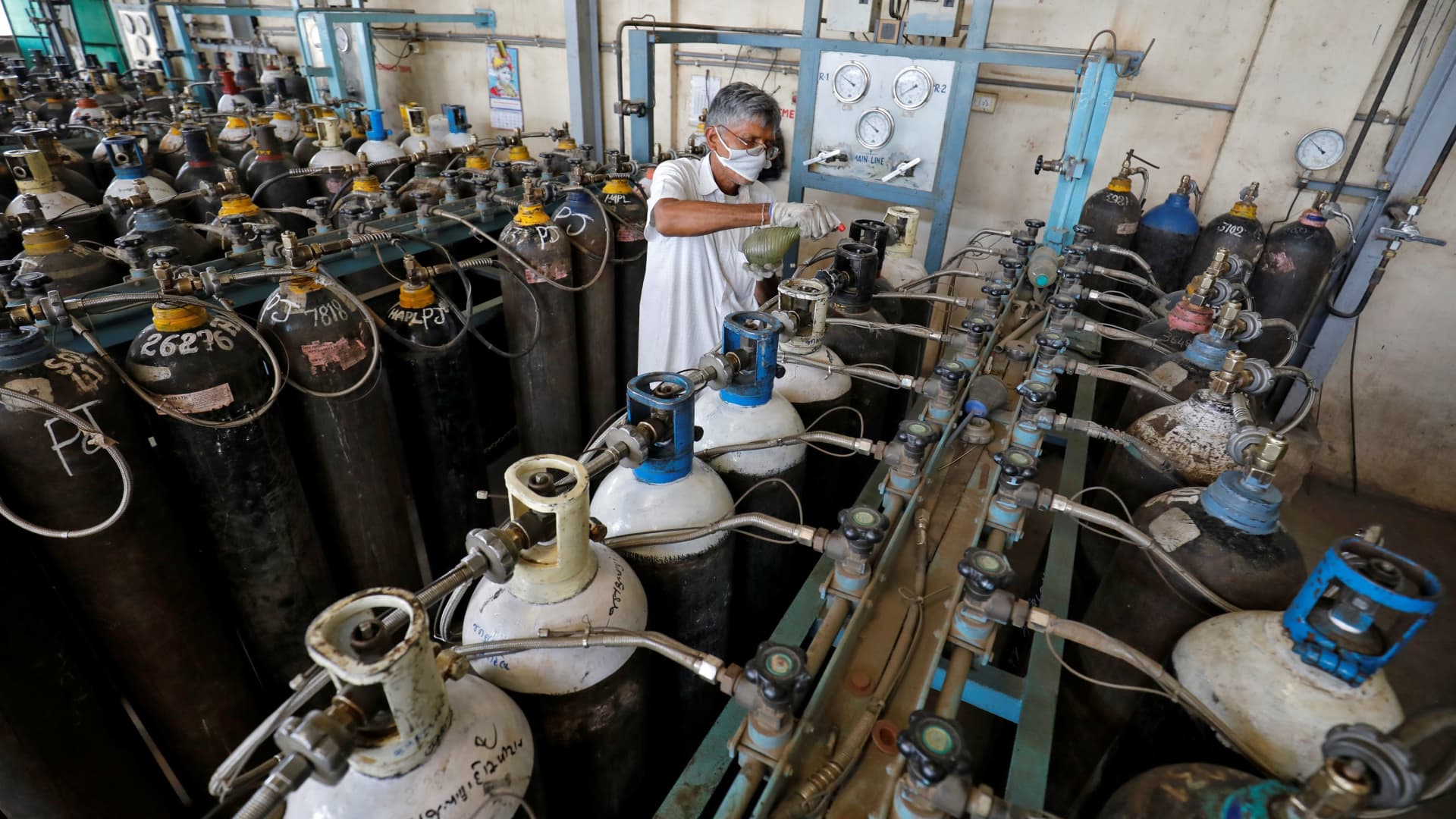 A worker disinfects nozzles of oxygen cylinders as they are refilled in a factory, amidst the spread of the coronavirus disease (COVID-19) in Ahmedabad, India, April 25, 2021.
