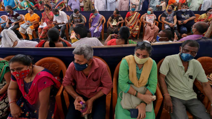 People wearing protective face masks wait to receive a vaccine for the coronavirus disease (COVID-19) at a vaccination centre in Mumbai, India, April 26, 2021.