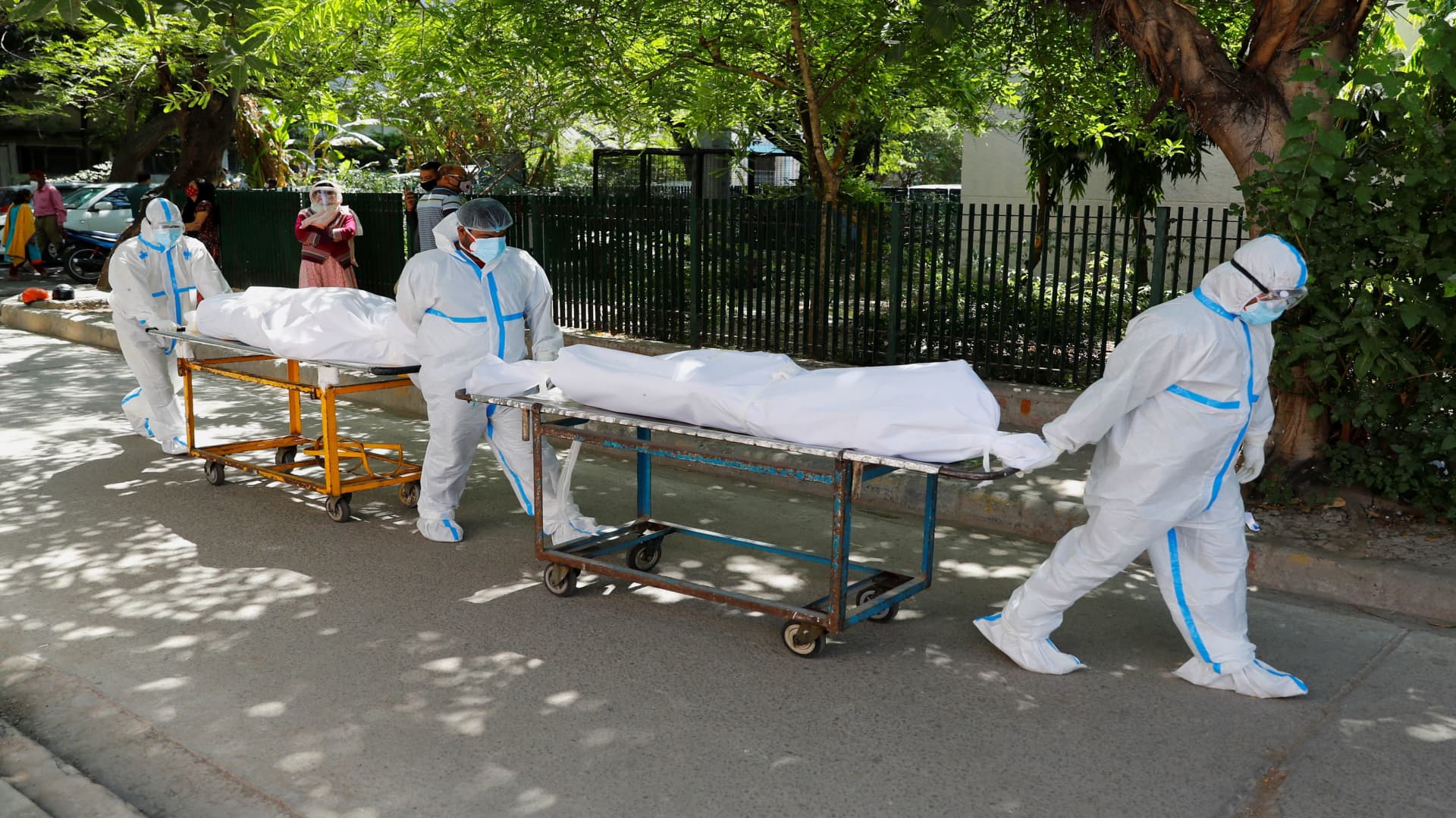 Health workers wearing personal protective equipment (PPE) carry bodies of people who were suffering from the coronavirus disease (COVID-19), outside the Guru Teg Bahadur hospital, in New Delhi, India, April 24, 2021.