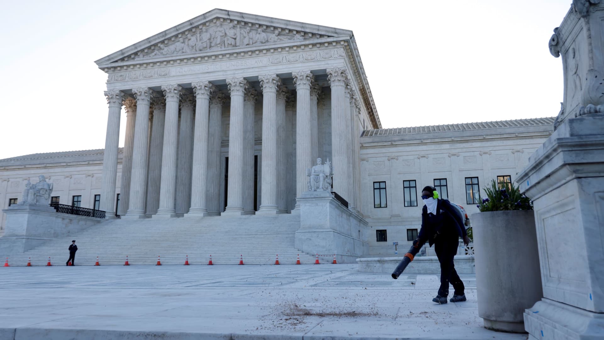 A worker clears front steps as morning rises over the U.S. Supreme Court building, still closed to the public during the coronavirus disease (COVID-19) outbreak in Washington, April 26, 2021.