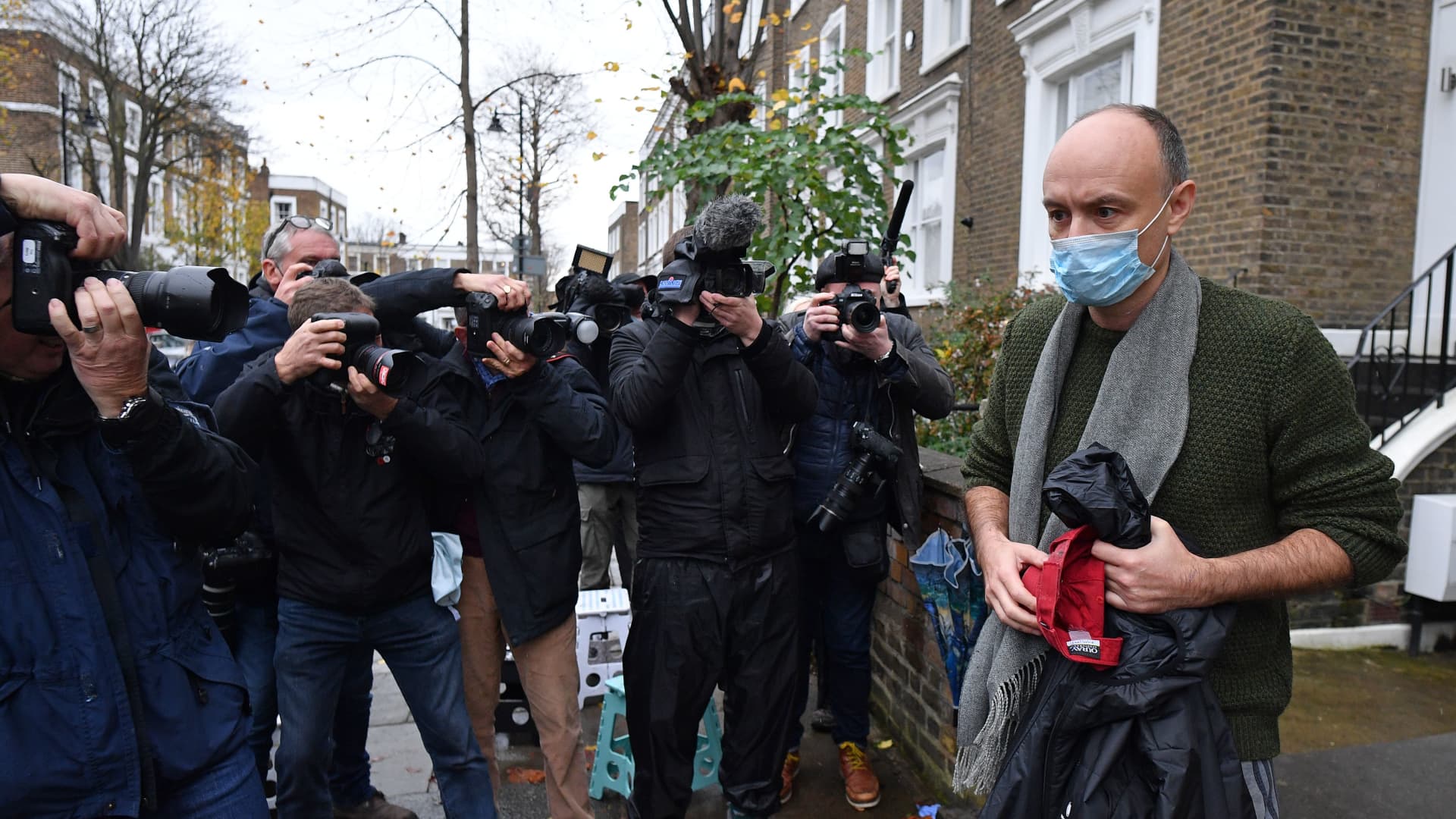 Members of the media surround former Number 10 special advisor Dominic Cummings (R) as he leaves his residence in London on November 14, 2020.