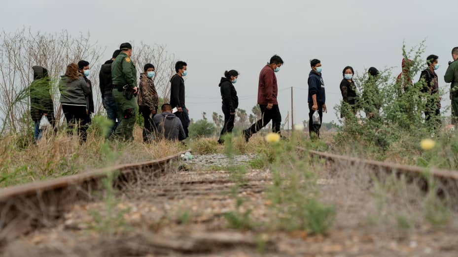 Central American migrants wait to be transported by the U.S. Border Patrol after crossing the Rio Grande river into the United States from Mexico in La Joya, Texas, U.S. April 27, 2021.