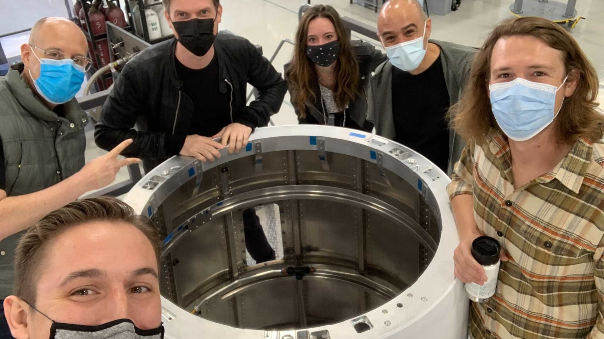 Members of Astra's leadership team gatherered around a rocket interstage in production, from right: VP of manufacturing Bryson Gentile, SVP of factory engineering Dr. Pablo Gonzalez, VP of communications Kati Dahm, founder and CEO Chris Kemp, EVP of engineering Benjamin Lyon.