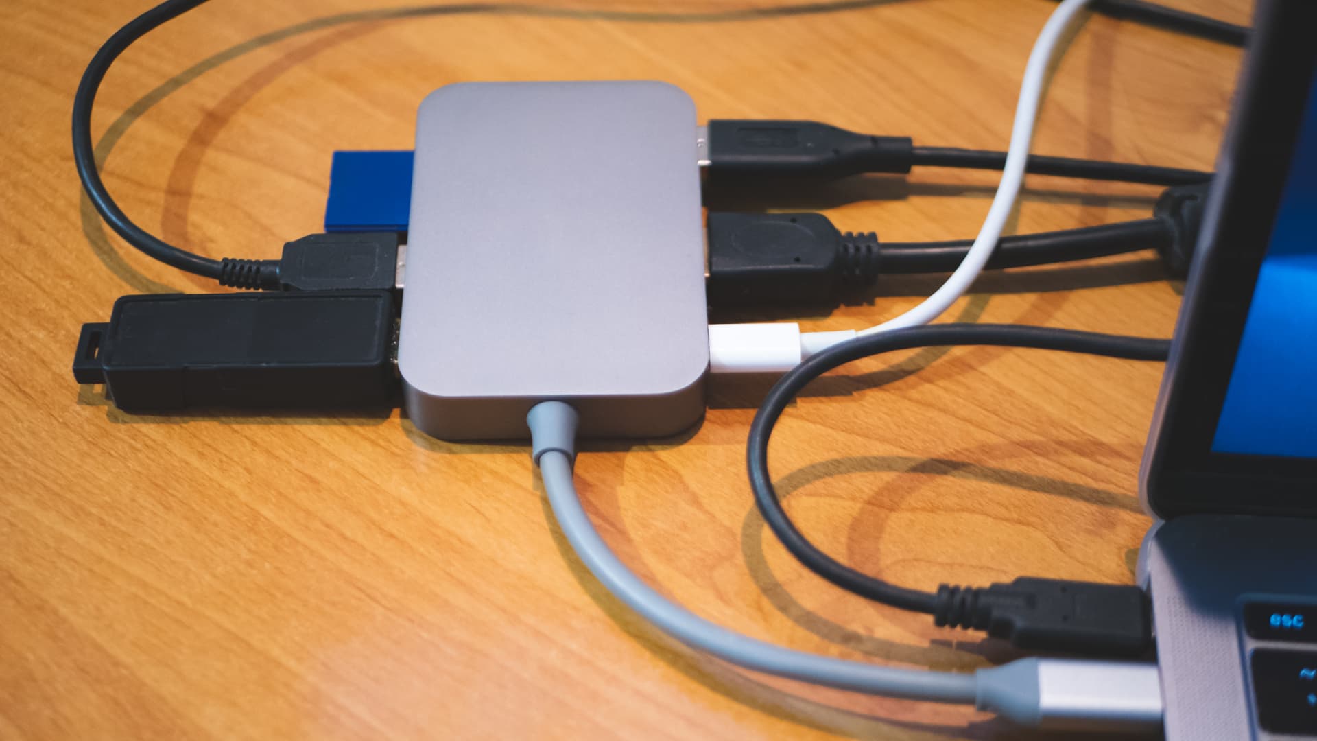USB Type-C hub connected to a laptop with cables connected for peripheral computer device equipment