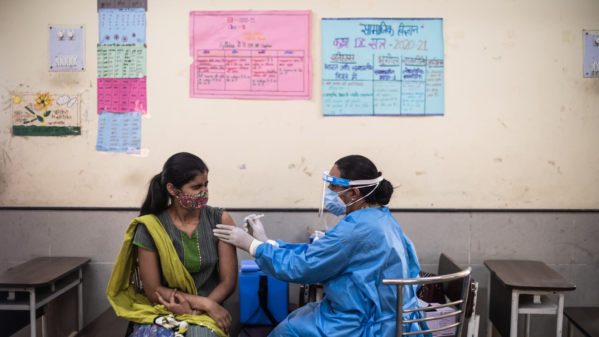 People receive their Covid-19 vaccines from medical workers at a vaccination centre set up in the classroom of a government school on May 04, 2021 in New Delhi, India.
