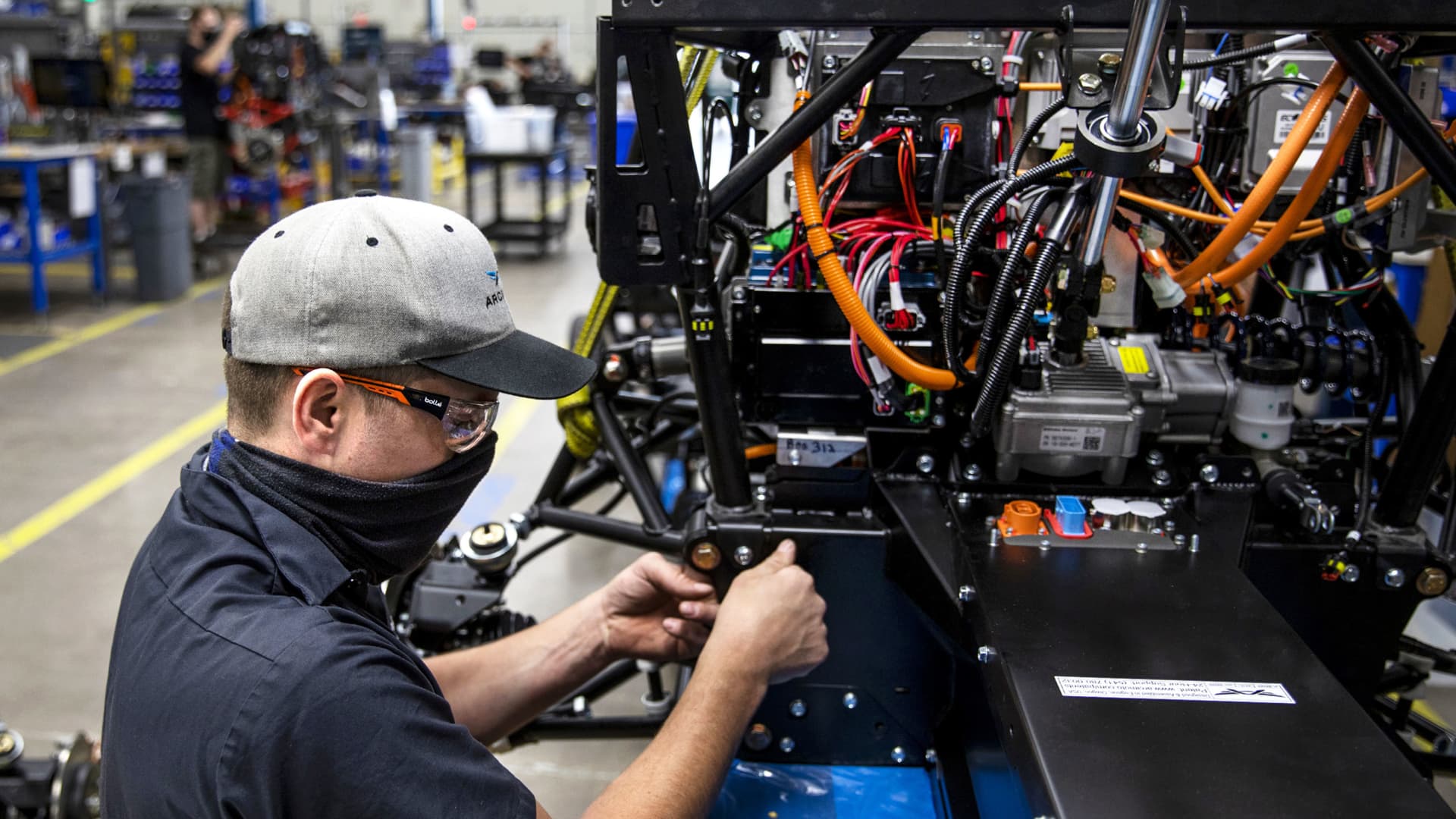 A worker attaches the front clip to the backbone on a three-wheeled electric fun utility vehicle (FUV) at the Arcimoto manufacturing facility in Eugene, Oregon, April 19, 2021.