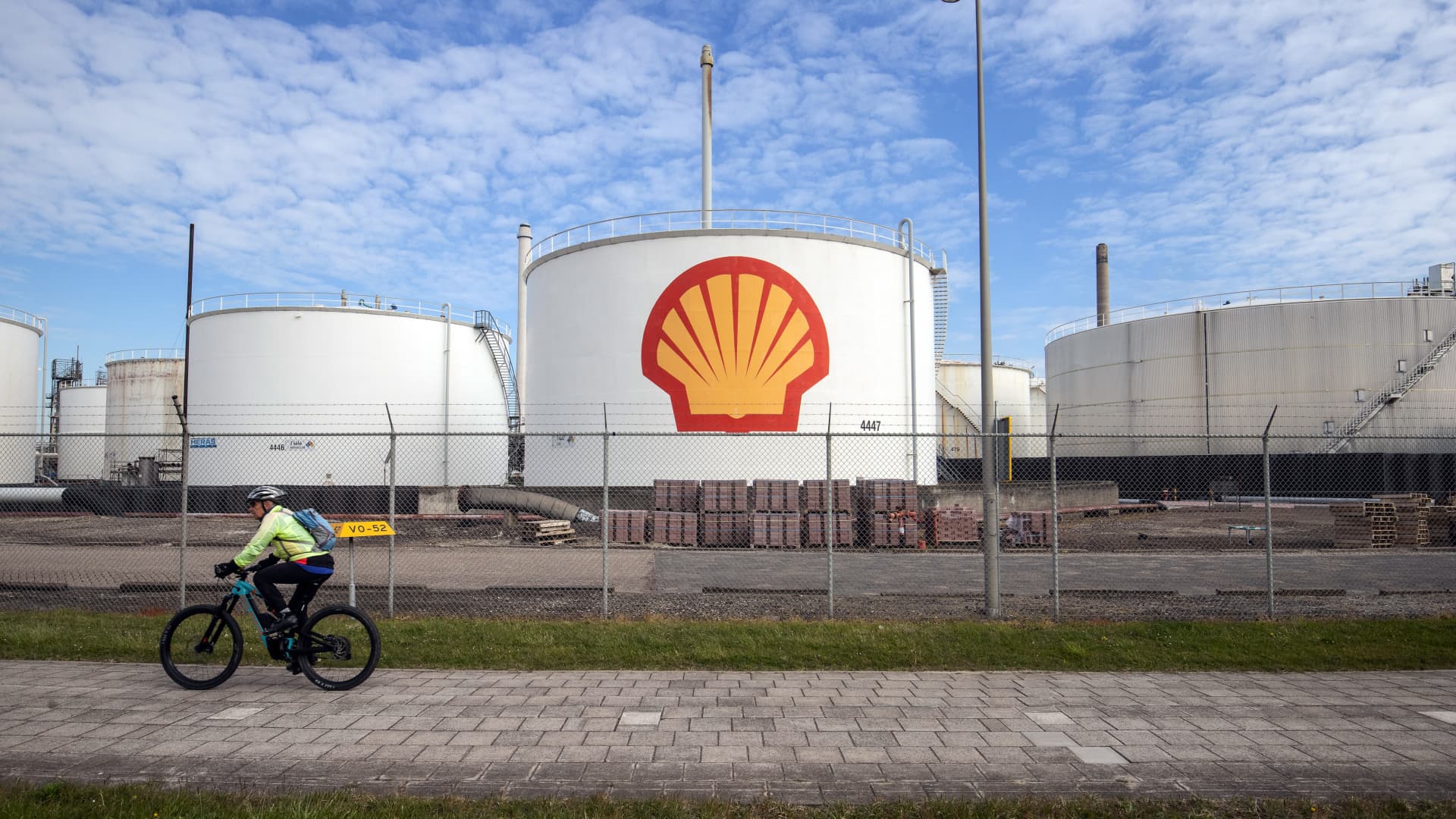 A cyclist passes oil silos at the Royal Dutch Shell Pernis refinery in Rotterdam, Netherlands, on Tuesday, April 27, 2021.
