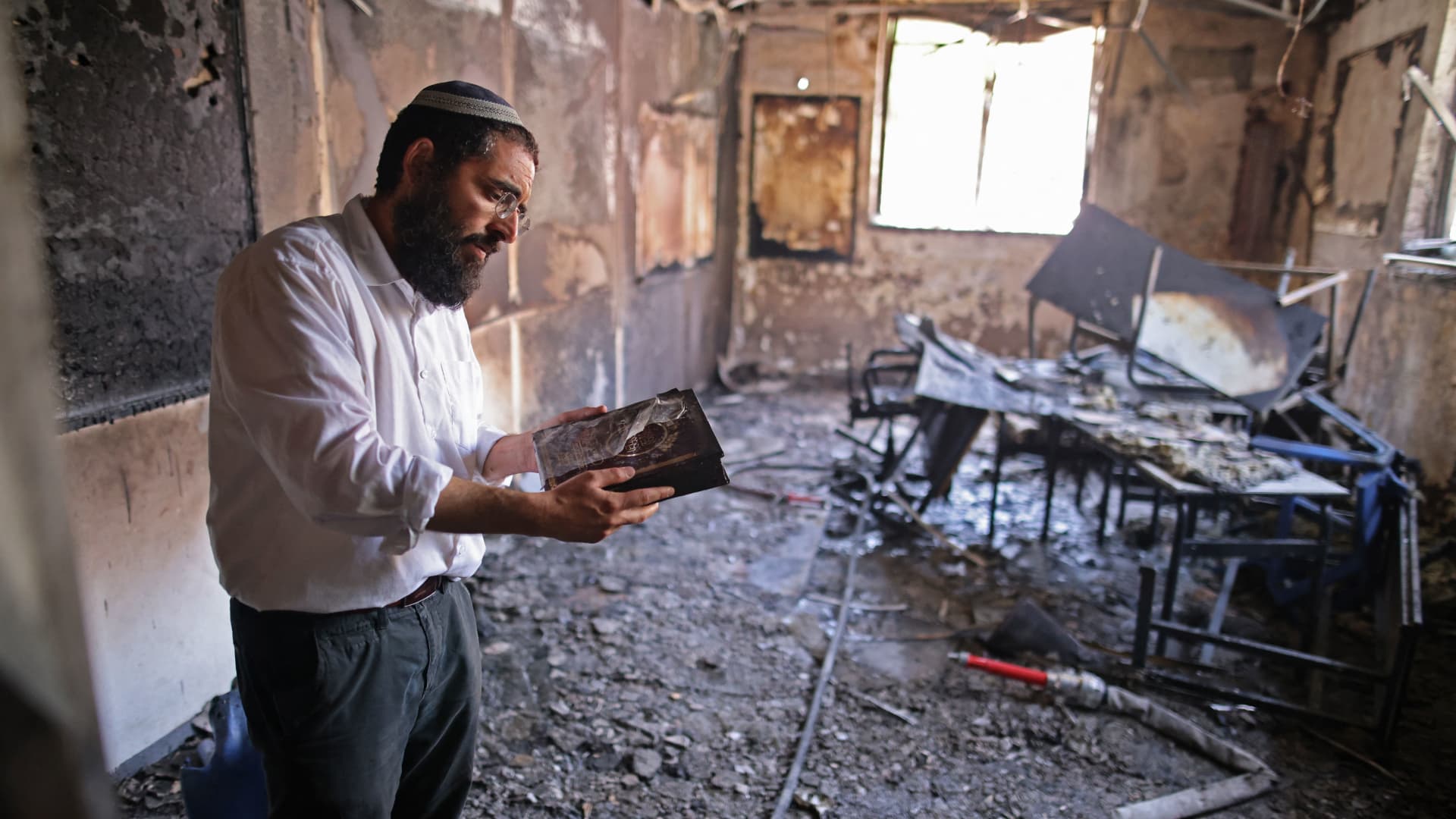 A rabbi inspects the damage inside a torched religious school in the central Israeli city of Lod, near Tel Aviv, on May 11, 2021, following night clashes between Arab Israelis and Israeli Jews.