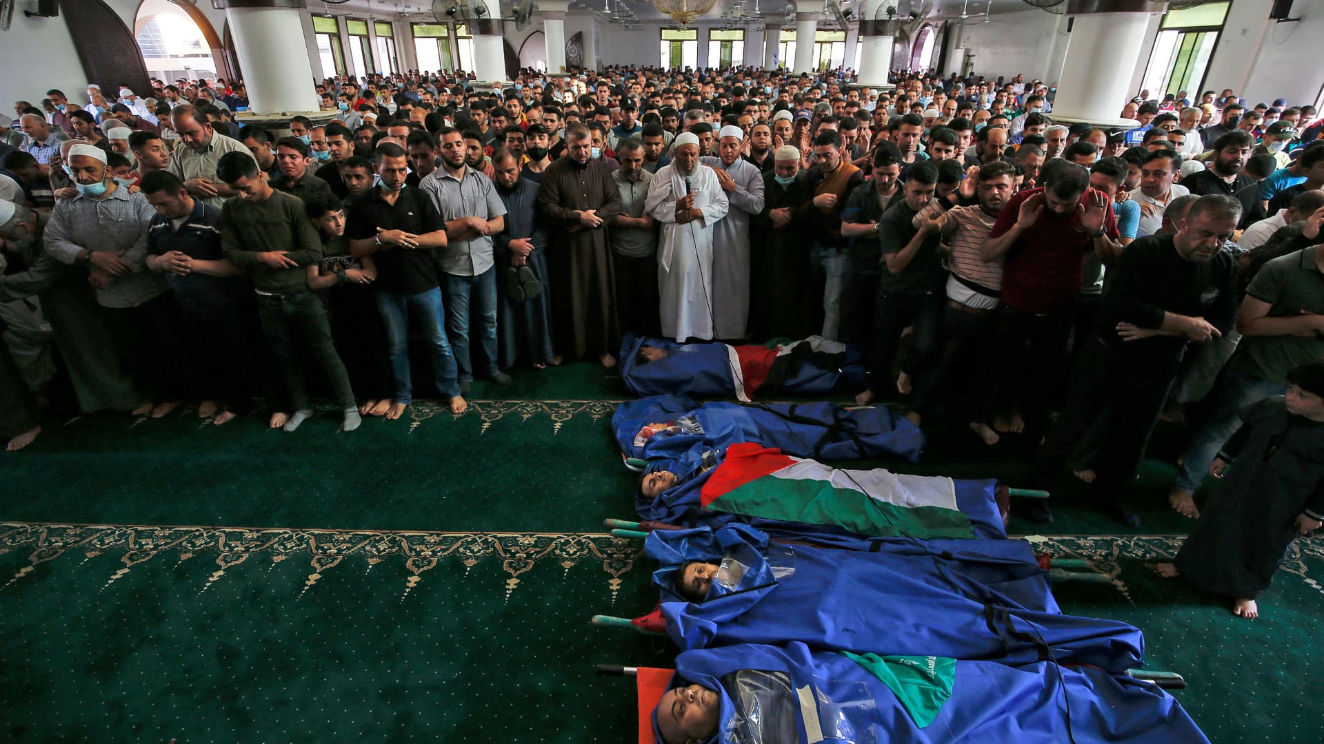 Palestinians pray over the bodies of people who were killed by Israeli airstrikes, during a funeral ceremony in Jabalia in the northern Gaza Strip on May 11, 2021.