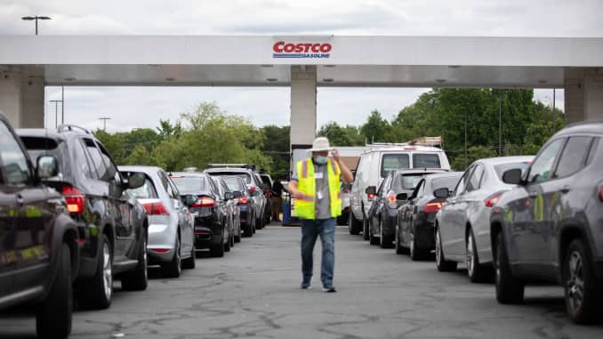Attendants direct cars as they line up to fill their gas tanks at a COSTCO on Tyvola Road in Charlotte, North Carolina on May 11, 2021.