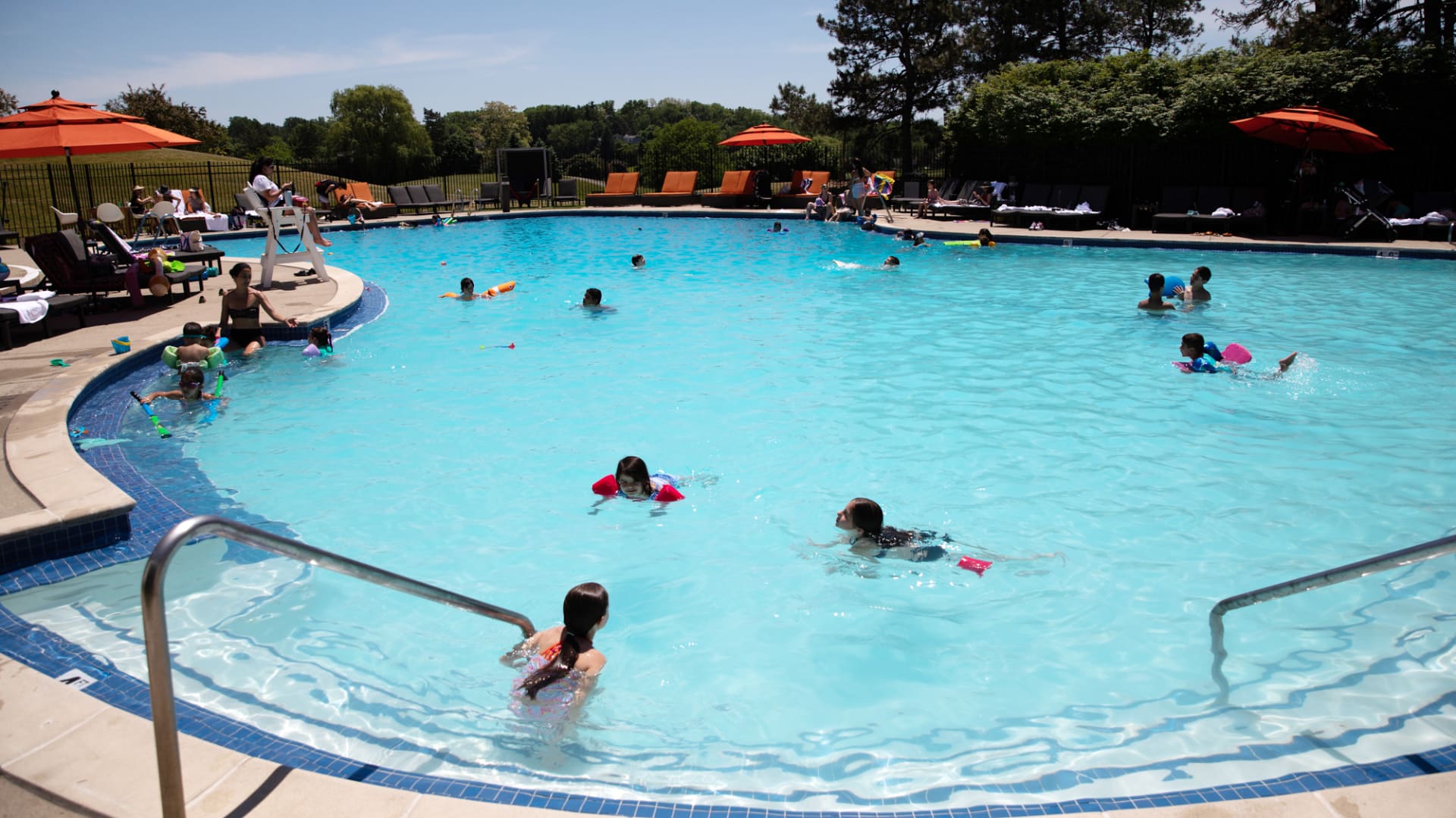 People swim in a pool at a country club in Bloomfield Hills Township, Michigan, U.S., on Monday, June 8, 2020.
