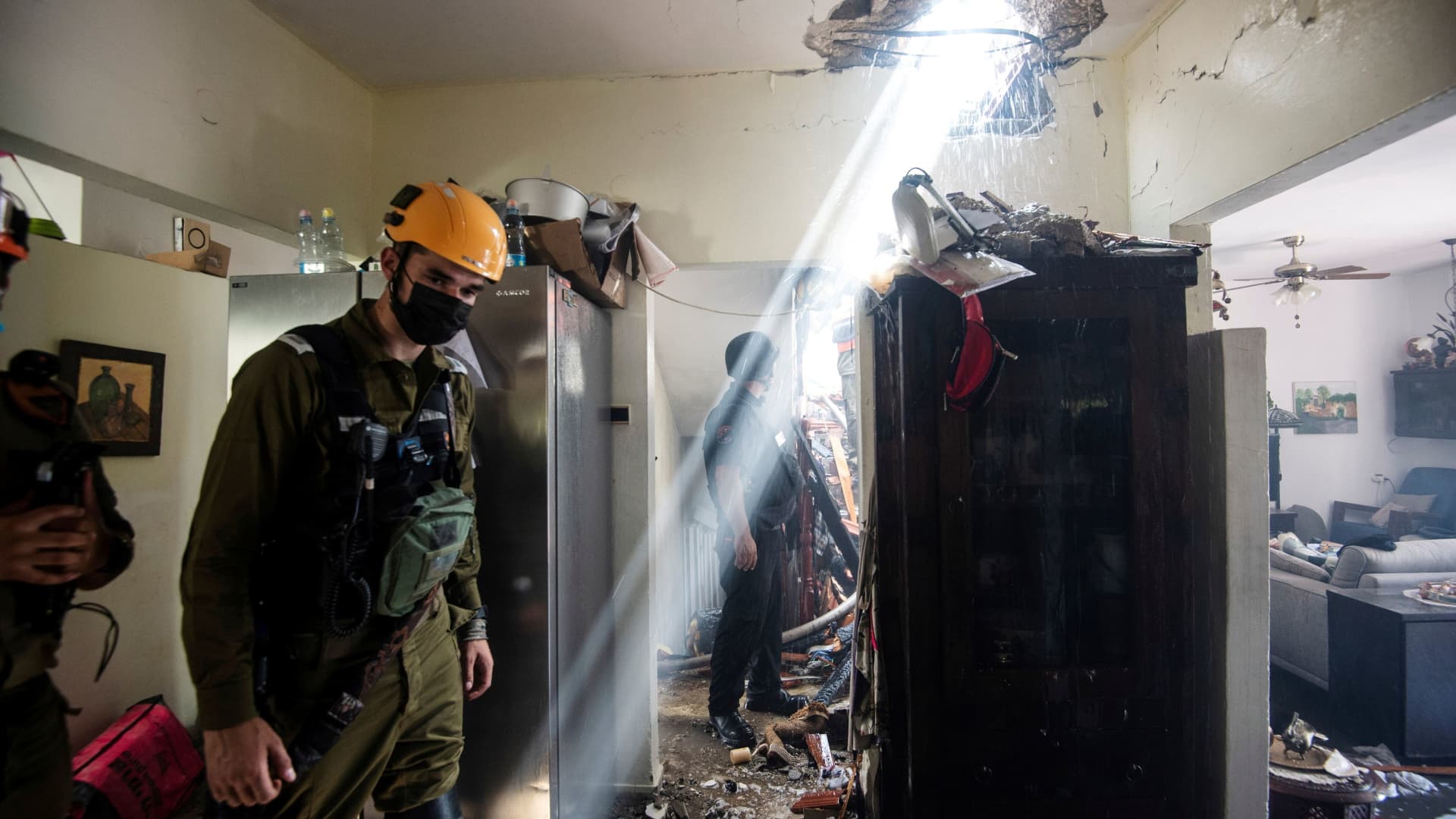 Soldiers work at a building damaged by a rocket launched from the Gaza Strip, in Ashdod, southern Israel, May 11, 2021.
