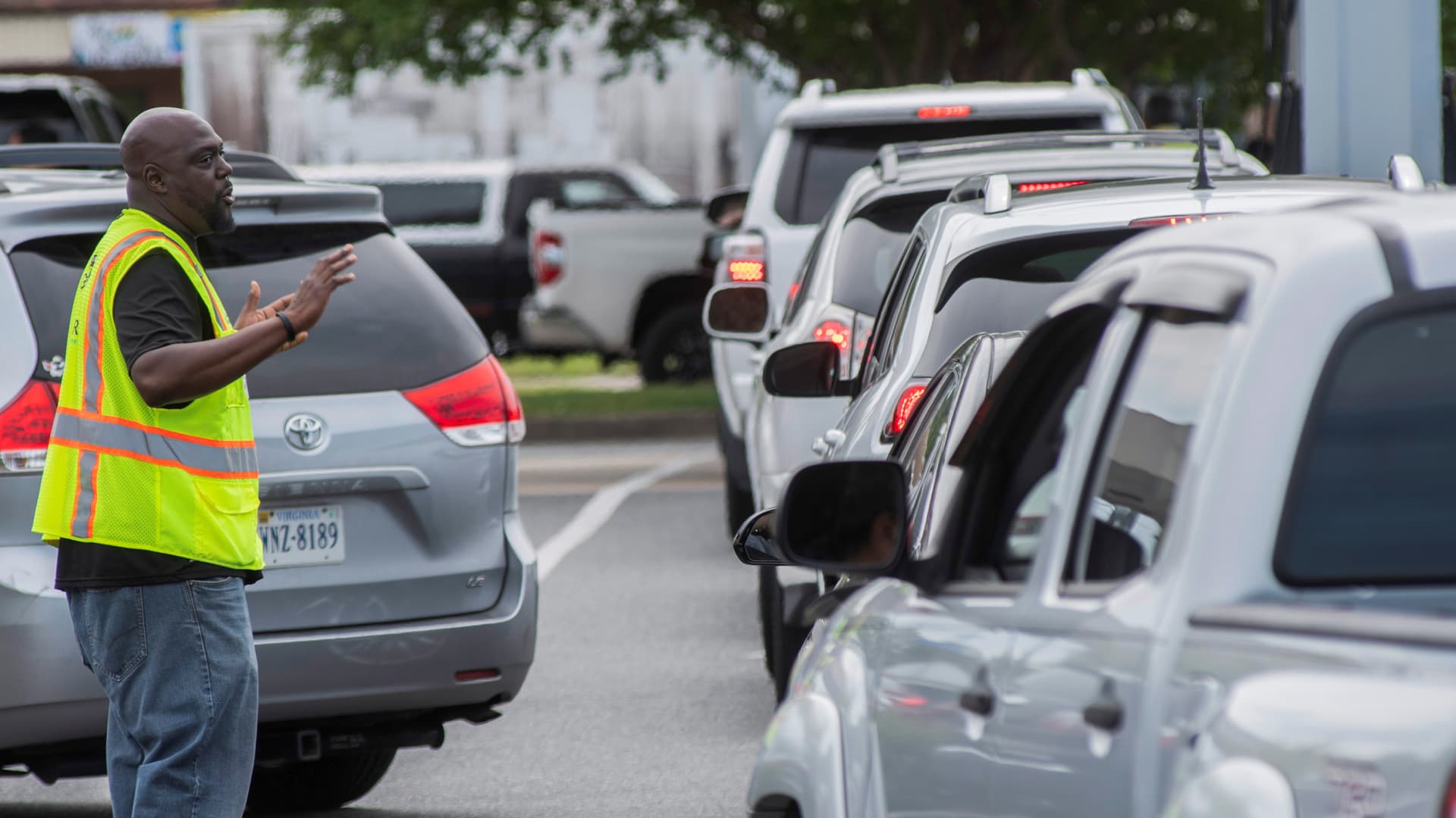 A line of vehicles proceeds towards gas pumps at Costco, as Eric Howard directs traffic after a cyberattack crippled the biggest fuel pipeline in the country, run by Colonial Pipeline, in Norfolk, Virginia, May 11, 2021.