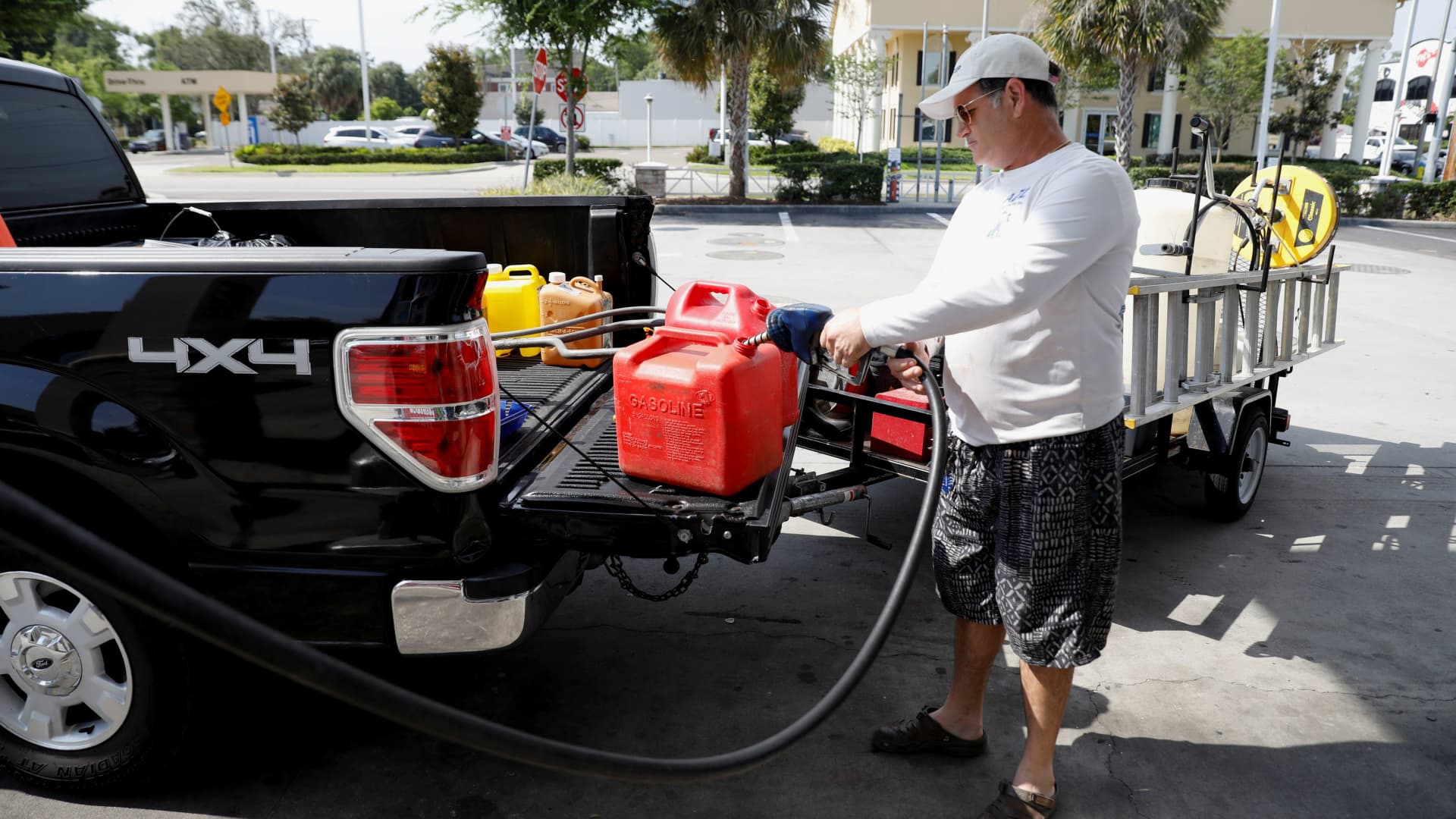 Dax Valenti fills up gas tanks at a gas station after a cyberattack crippled the biggest fuel pipeline in the country, run by Colonial Pipeline, in Tampa, Florida, May 12, 2021.