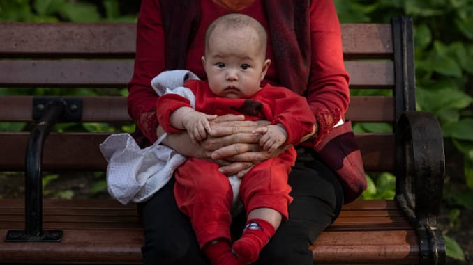 A woman holds a baby at a local park on May 12, 2021 in Beijing, China.