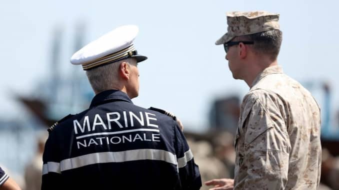 U.S. Marine Maj. Christopher Warnagiris interacts with a French Navy officer during the embarkation of the 15th Marine Expeditionary Unit aboard the French amphibious assault ship LHD Tonnerre (L9014)