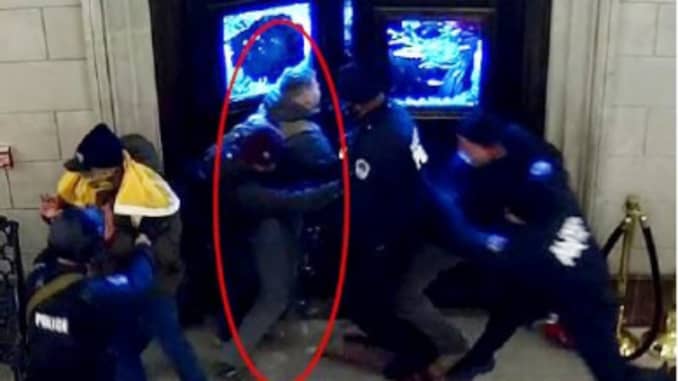 A still from a video released by the D.O.J. showing Christopher Warnagiris (circled in red), who is a Marine Corps commissioned officer stationed at the Marine Corps Base Quantico was arrested today in Virginia and charged with crimes related to the breac