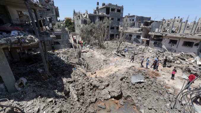 Palestinians gather at the site of destroyed houses in the aftermath of Israeli air and artillery strikes as cross-border violence between the Israeli military and Palestinian militants continues, in the northern Gaza Strip May 14, 2021.