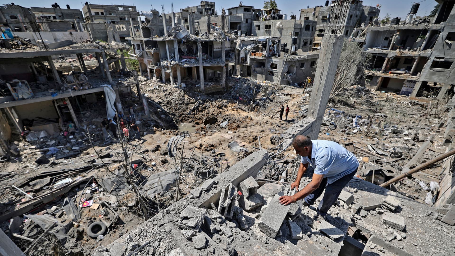 Palestinians assess the damage caused by Israeli airstrikes, in Beit Hanun in the northern Gaza Strip, on May 14, 2021.